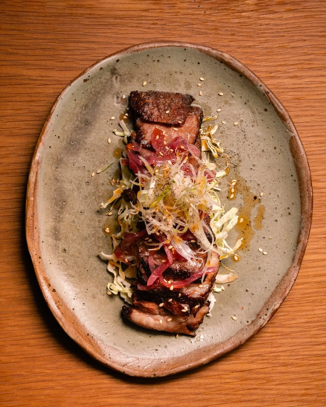 BEEF SHORT RIB

Bulgogi glaze. Leek. Pickled onions. Cabbage slaw.

Slow, sticky, and just the right kind of sweet.
Watch the glaze drip then try not to drool.