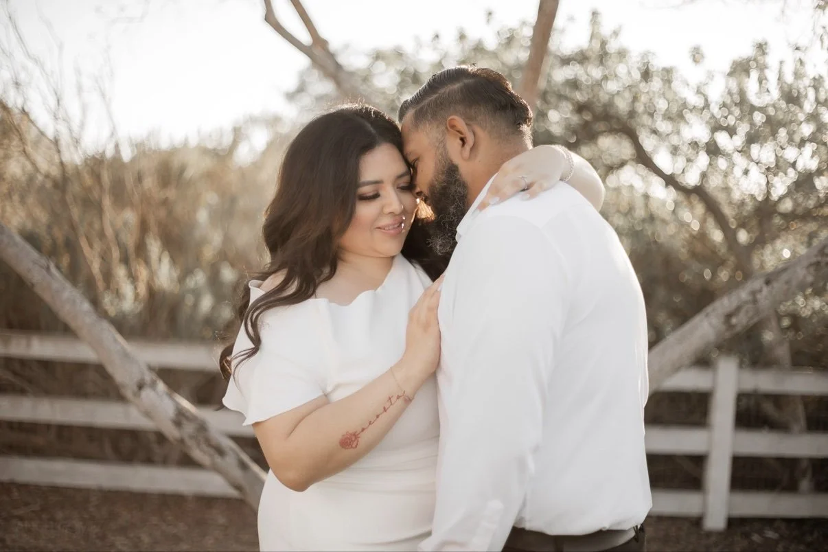 Engagement photo of a couple embracing in white