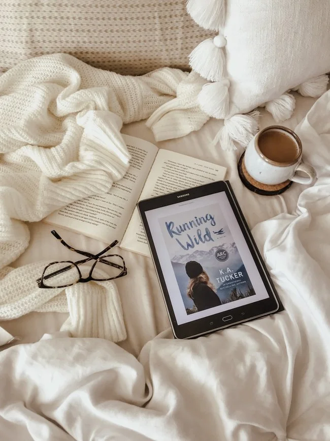 Running Wild cover image on an ereader on a cozy bed with coffee