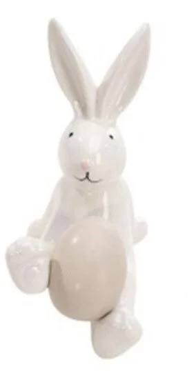 White ceramic rabbit holding a beige egg