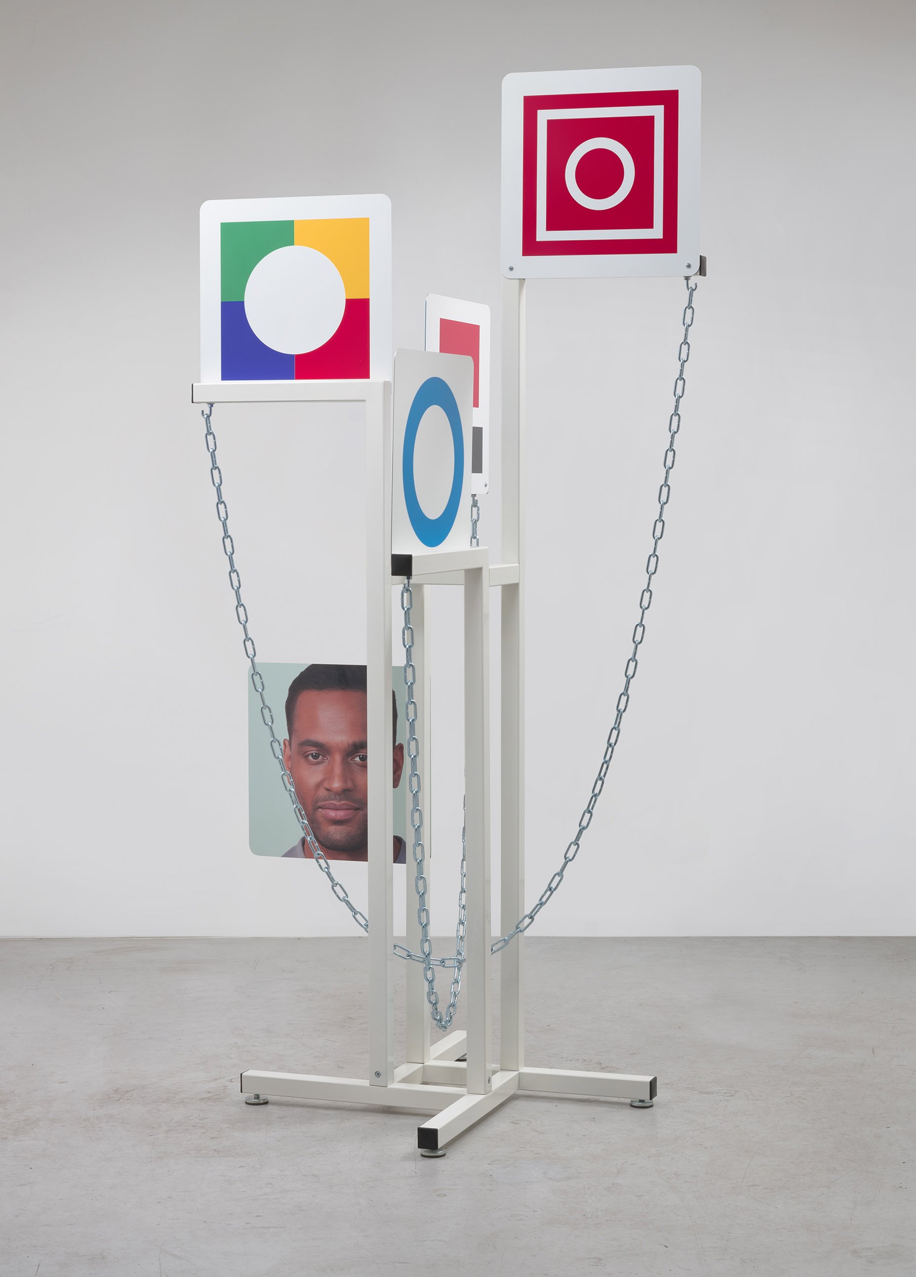  David Schafer  Displayer , 2021 fabricated and powder steel, chain, printed aluminum signs, hardware, AI generated face 91 x 44 x 44 in (231.1 x 111.8 x 111.8 cm) 