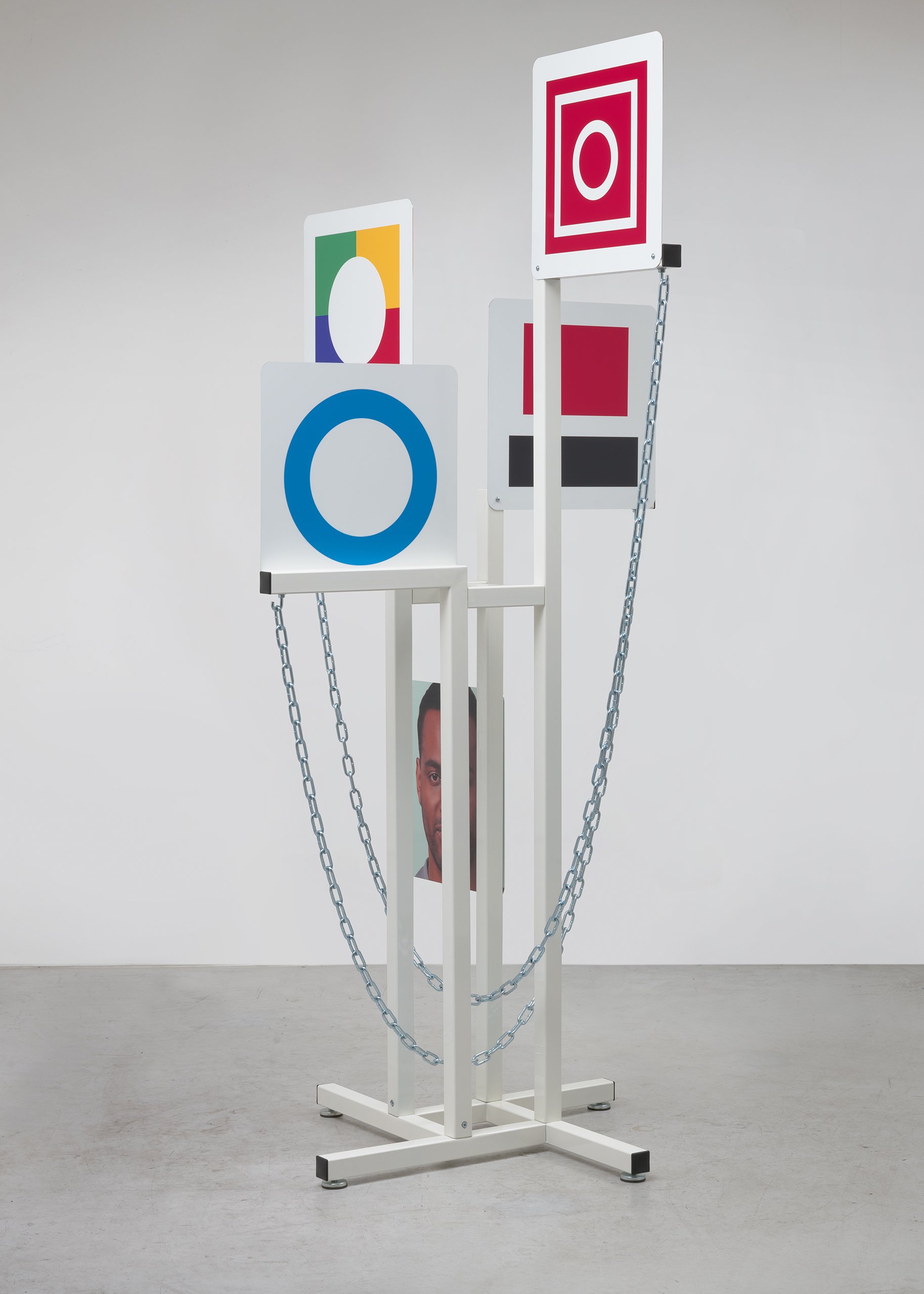  David Schafer  Displayer , 2021 fabricated and powder steel, chain, printed aluminum signs, hardware, AI generated face 91 x 44 x 44 in (231.1 x 111.8 x 111.8 cm) 