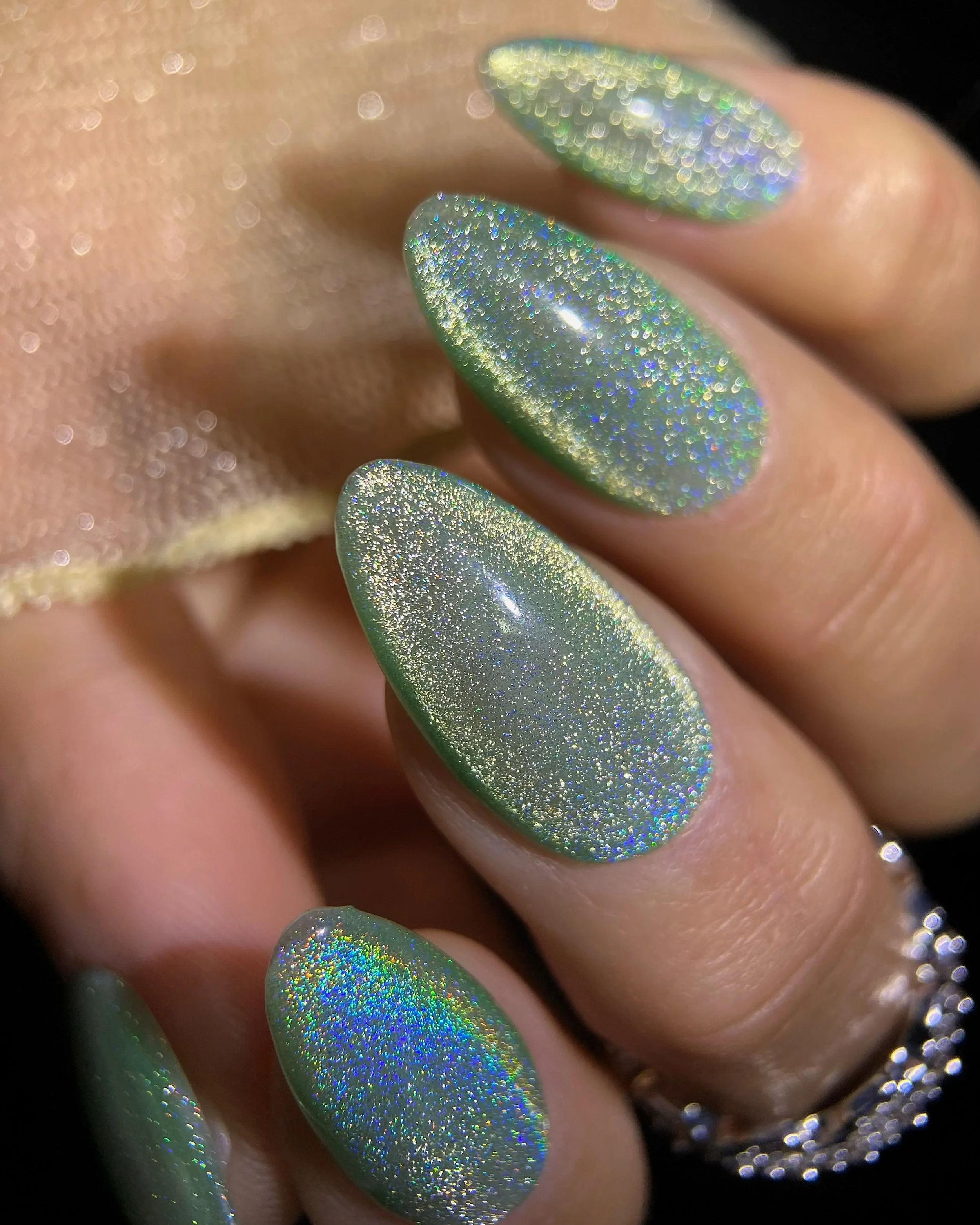 Close-up swatch of Kokoist Rainbow Green (UCM-05) holographic magnet gel on almond shaped nails