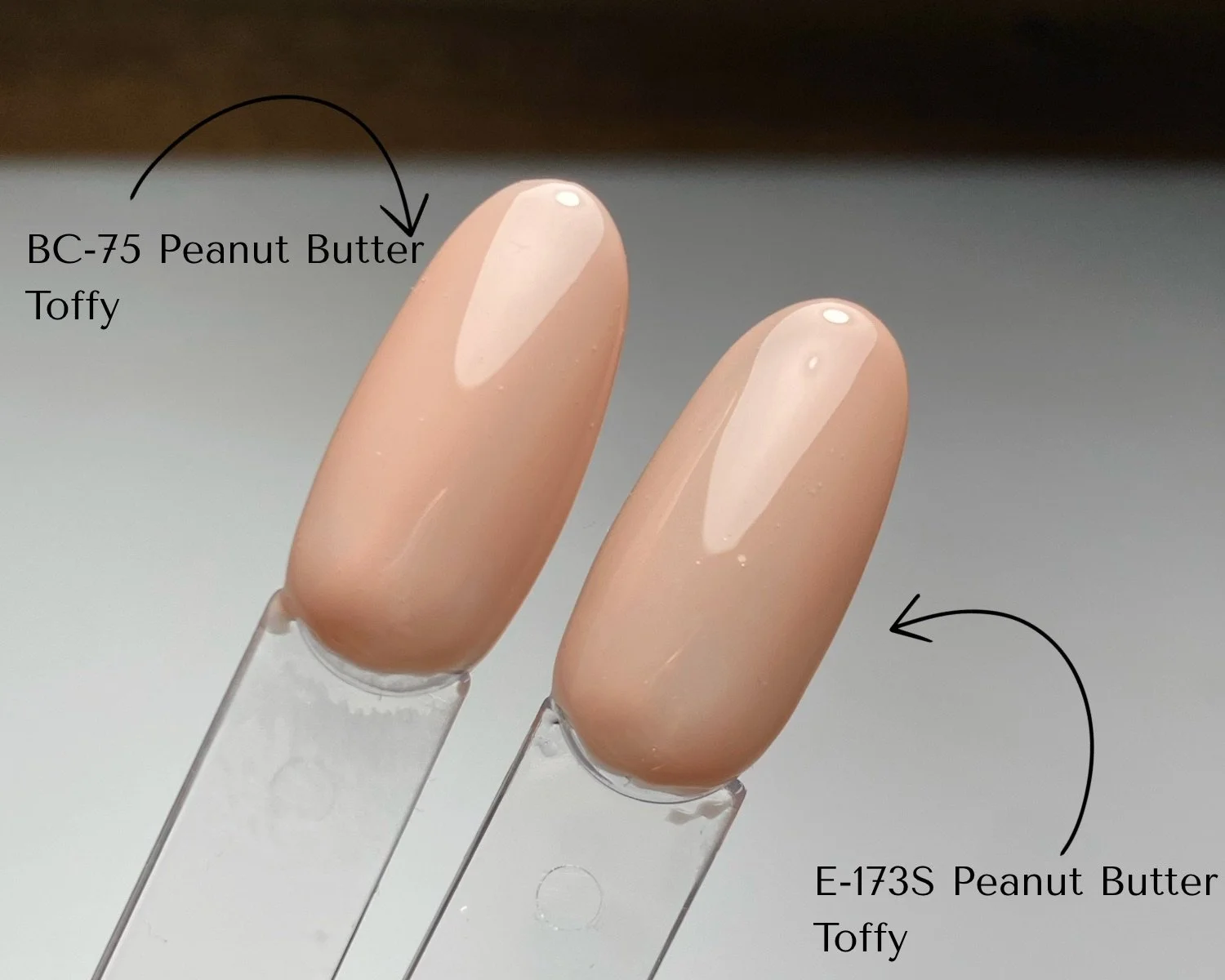 Side-by-side comparison of KOKOIST Bottle'N Go BC-75 Peanut Butter Toffy and Excel Color E-173S Peanut Butter Toffy swatched on clear swatch sticks.