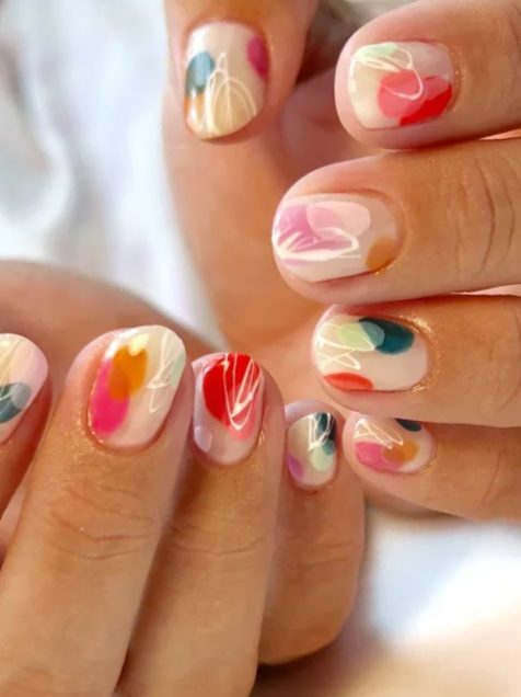 Structured gel manicure with colorful abstract nail art and fine white line details.