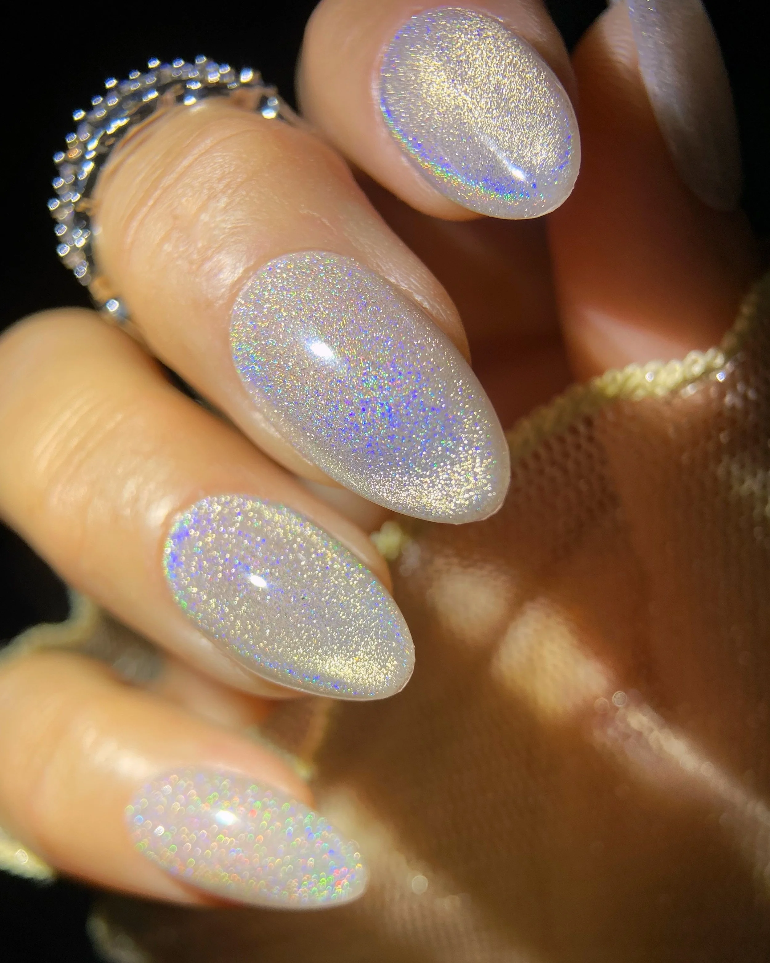 Close-up swatch of Kokoist Rainbow Clear (UCM-01) holographic magnet gel on almond shaped nails