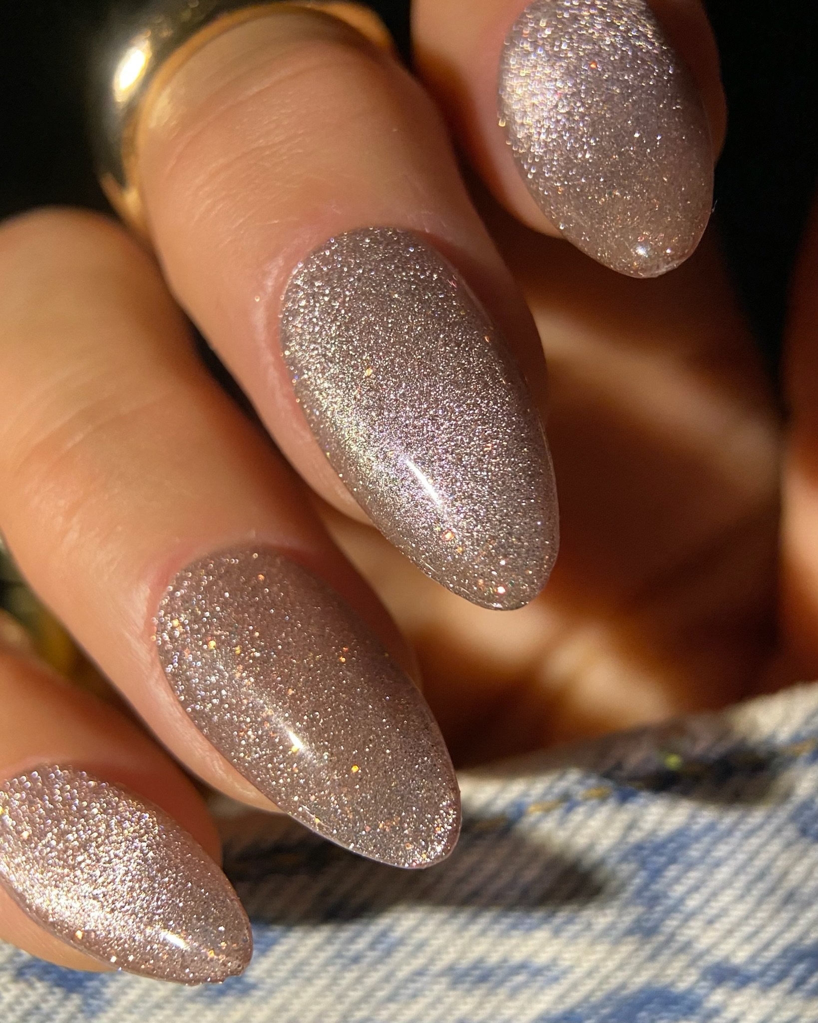 Hand with magnetic cat-eye gel polish on almond nails