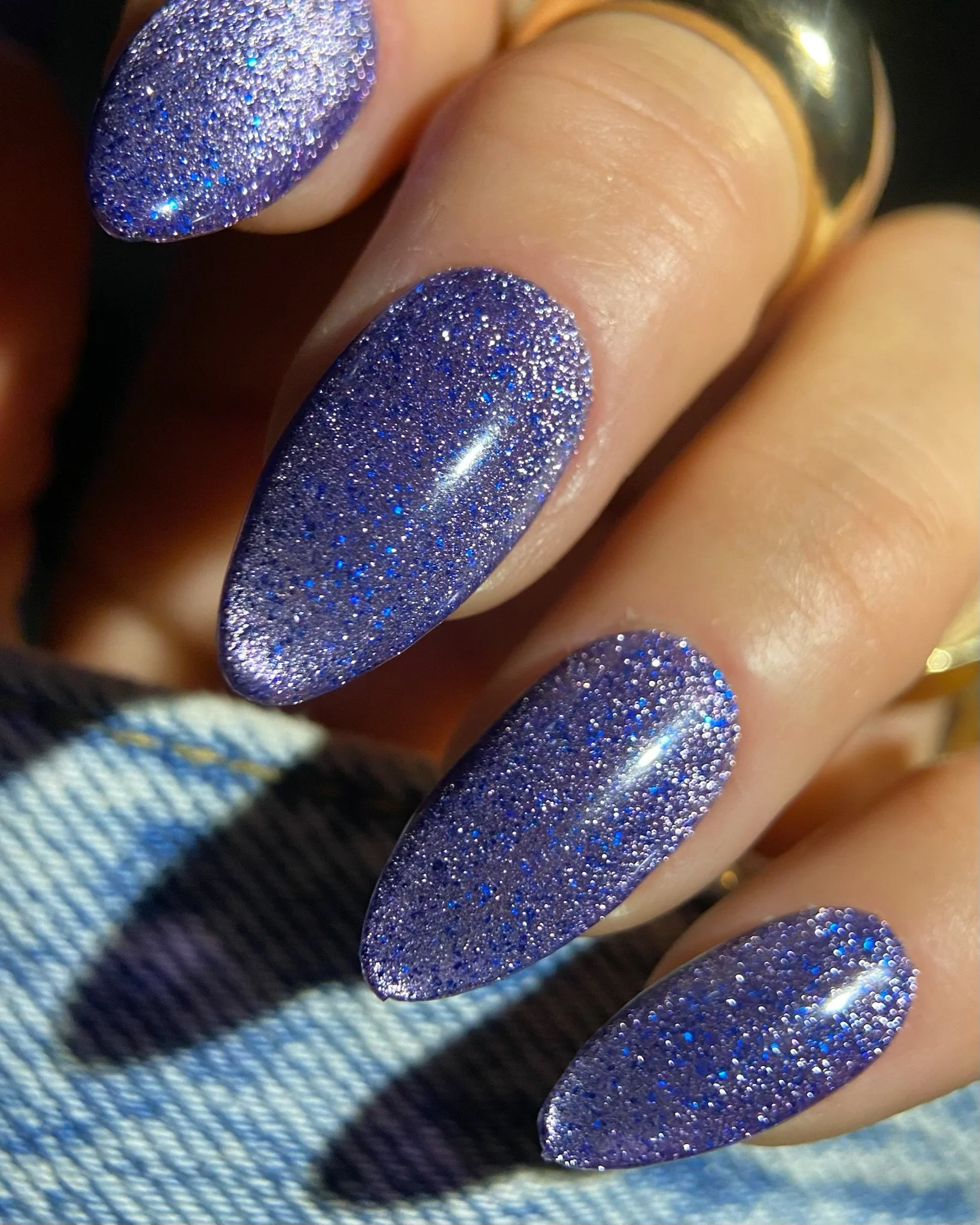 Close-up view of hand with blue glittery nails