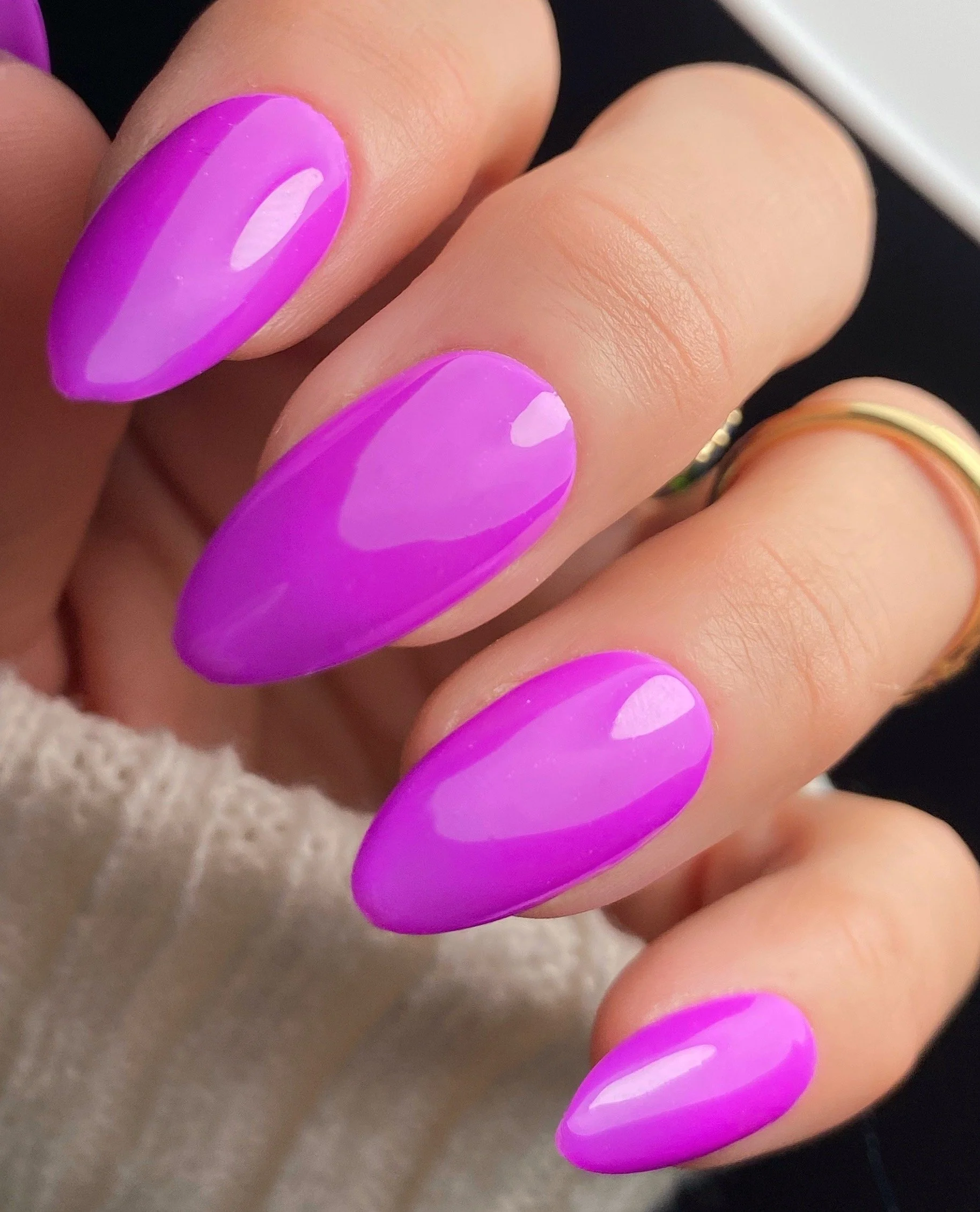 Nail Thoughts Celebration Collection gel color swatch in shade "This is my song!" a bright purple on manicured hand with rings and knit sleeve.