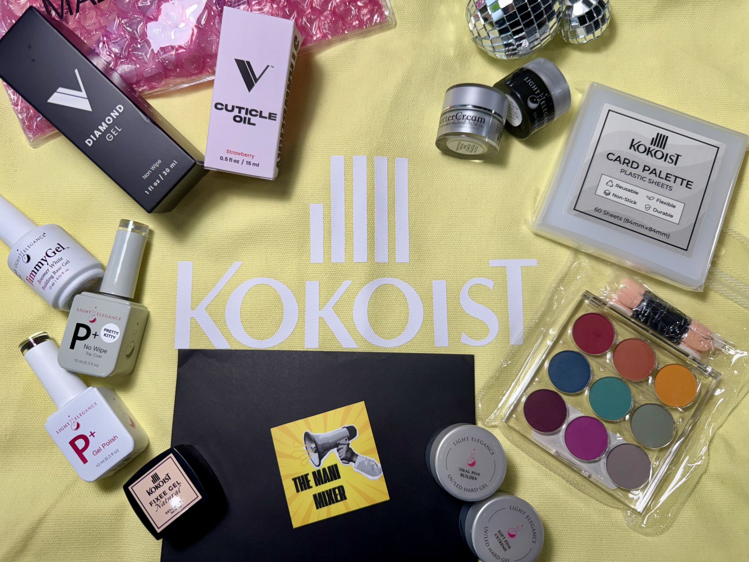 The Mani Mixer 2026 attendee gift bag featuring KOKOIST products, Light Elegance gels, and the Vacation Nail Shop Victoria Soft Fade Gradient Palette.