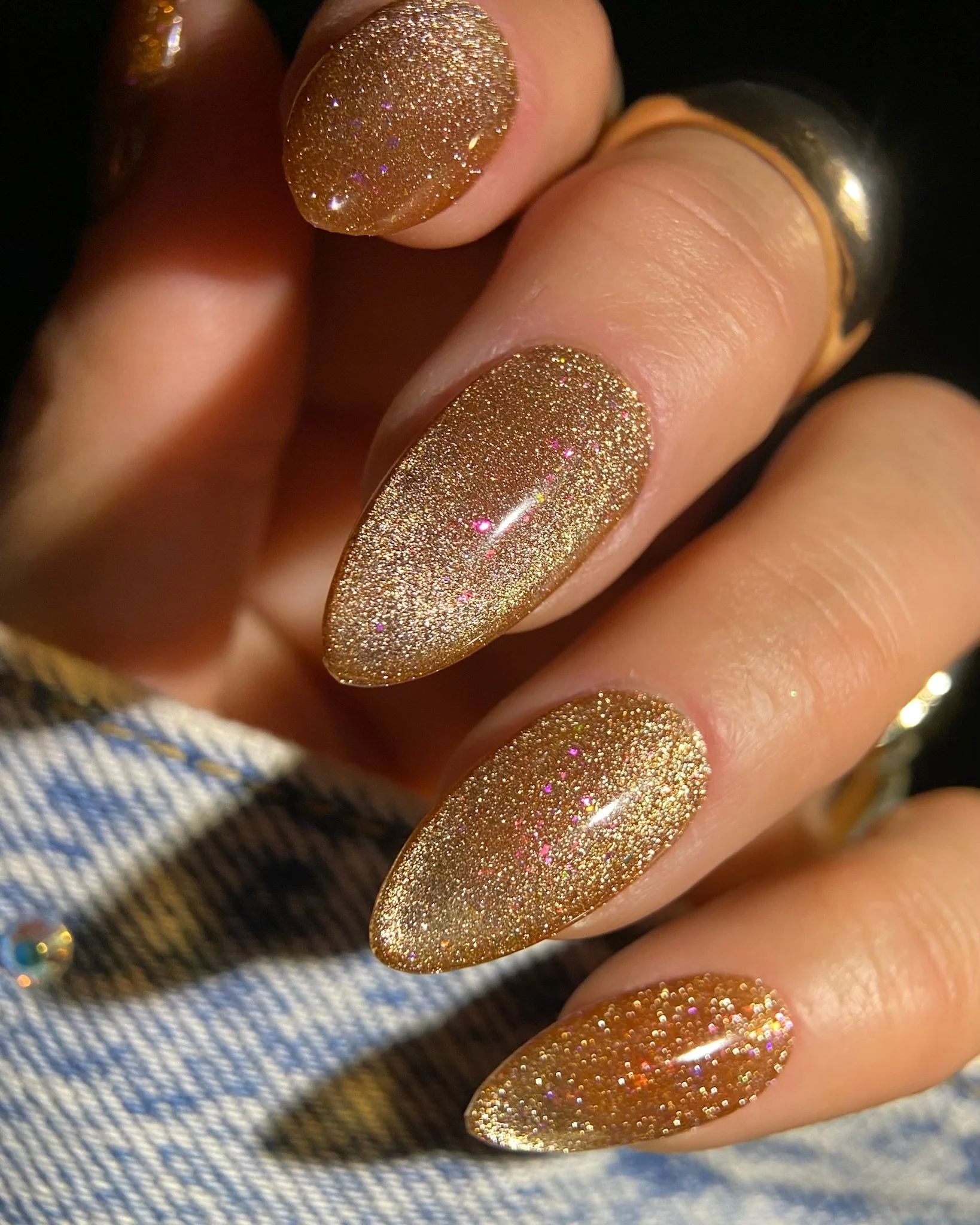 Close-up of hand with gold glittery nails.