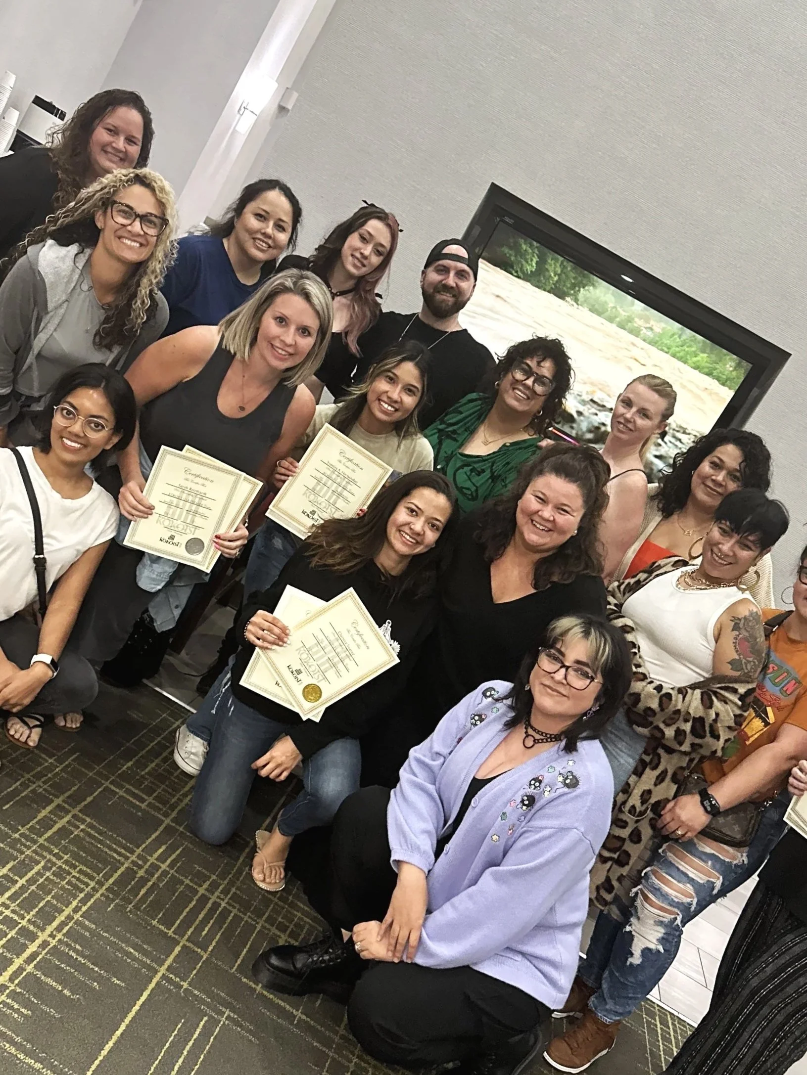 Students and educators posing for a group photo after completing a professional nail certification class.