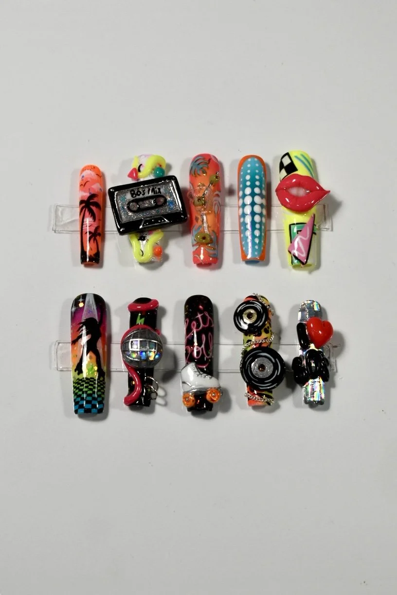 Totally '80s nail art competition entry at The Mani Mixer 2026 featuring cassette tapes, roller skates, disco balls, tropical sunsets, boomboxes, and bright retro-inspired sculptural details.