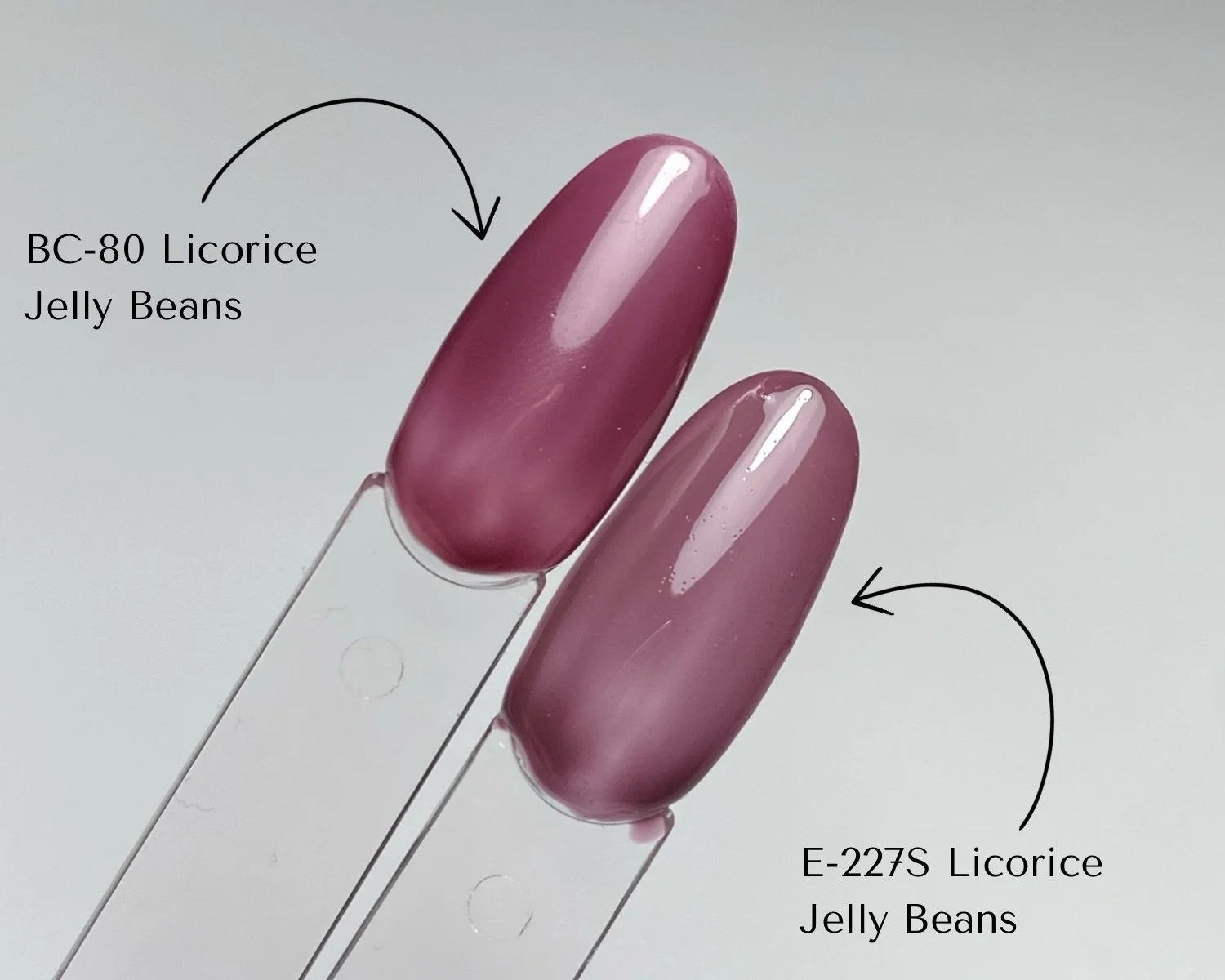 Side-by-side comparison of KOKOIST Bottle'N Go BC-80 Licorice Jelly Beans and Excel Color E-227S Licorice Jelly Beans swatched on clear swatch sticks.