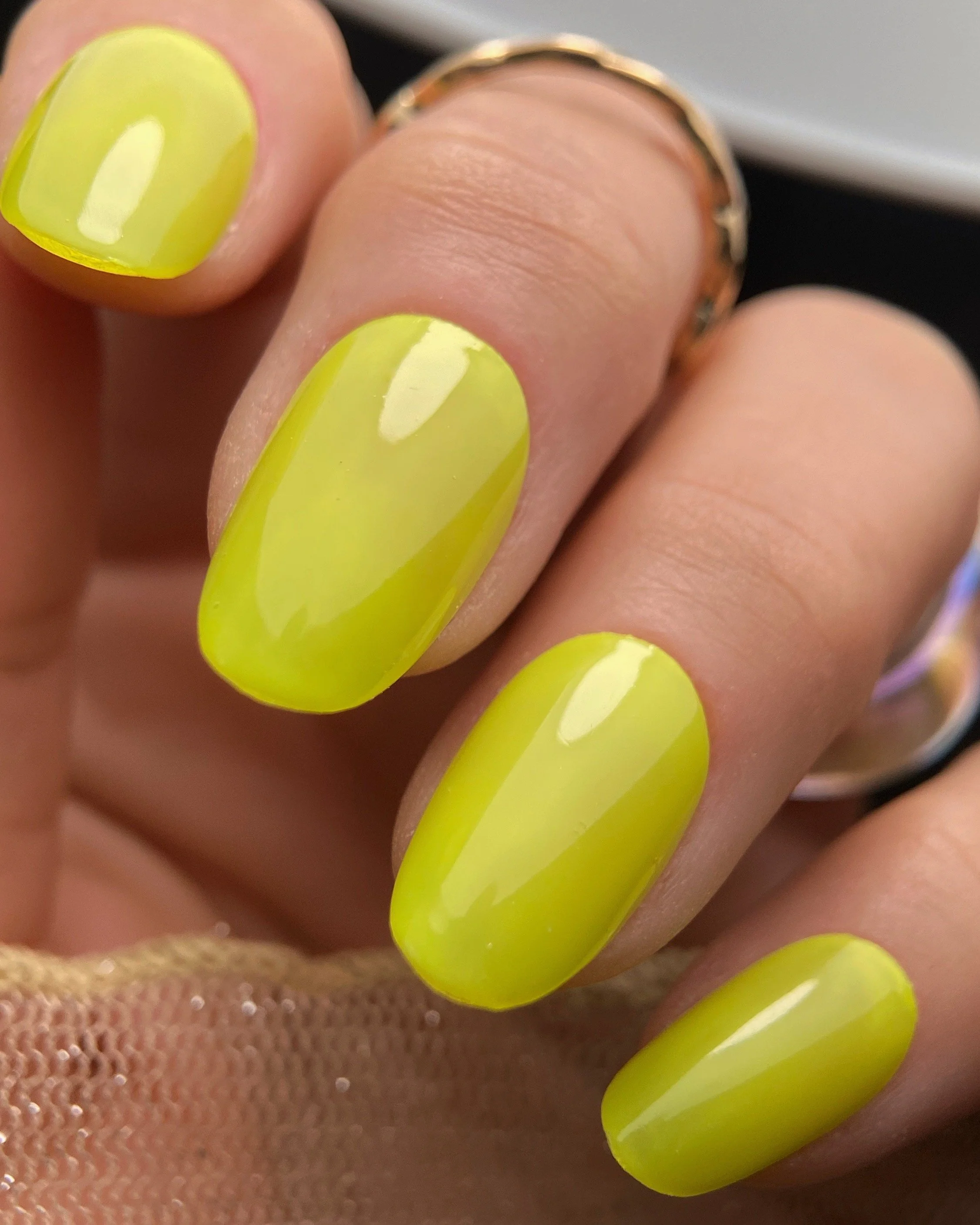 Close-up swatch of Orly In The Limelight chartreuse neon nail polish on almond shaped nails.