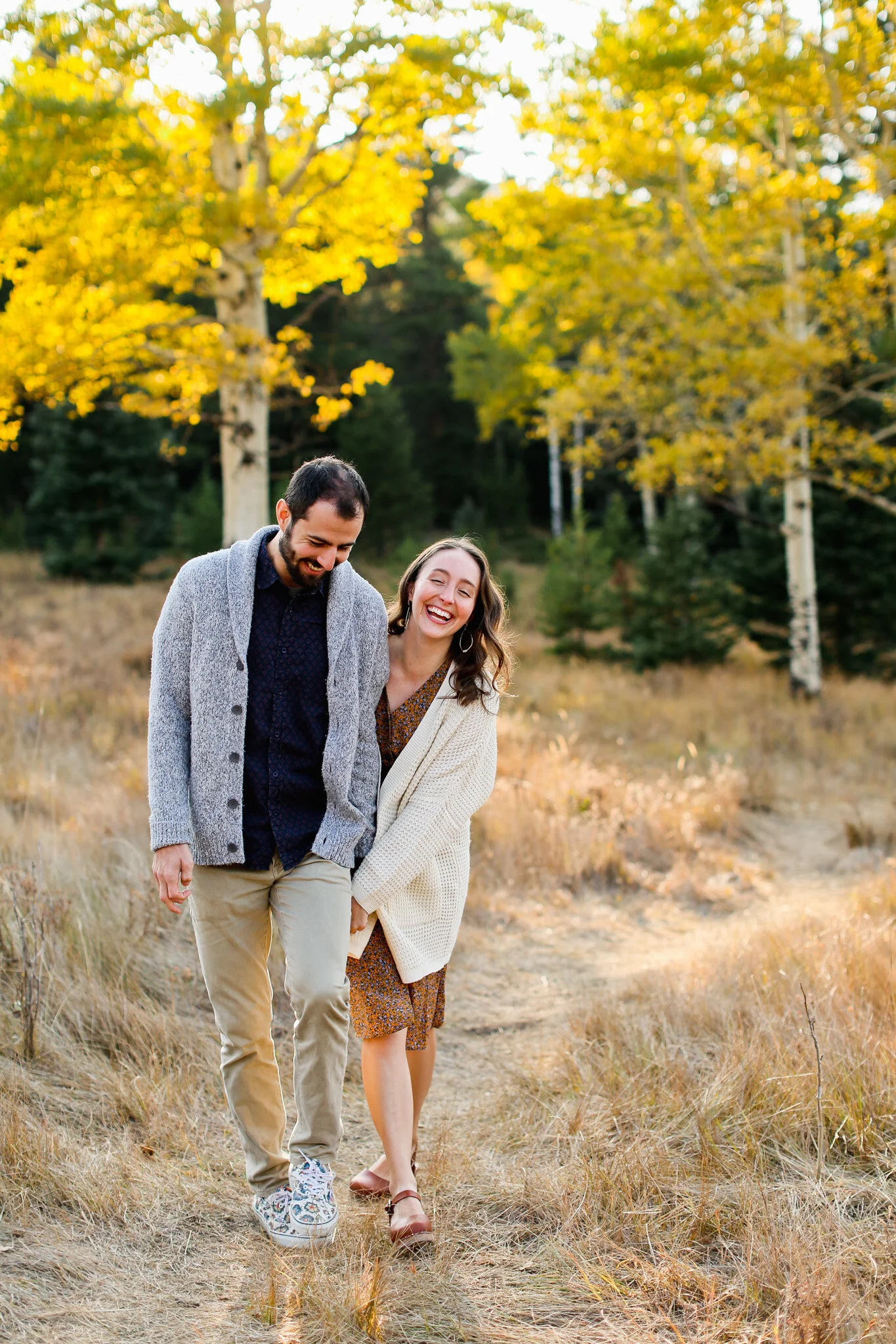 Colorado engagement photographer - couple walking in aspen tress in Evergreen