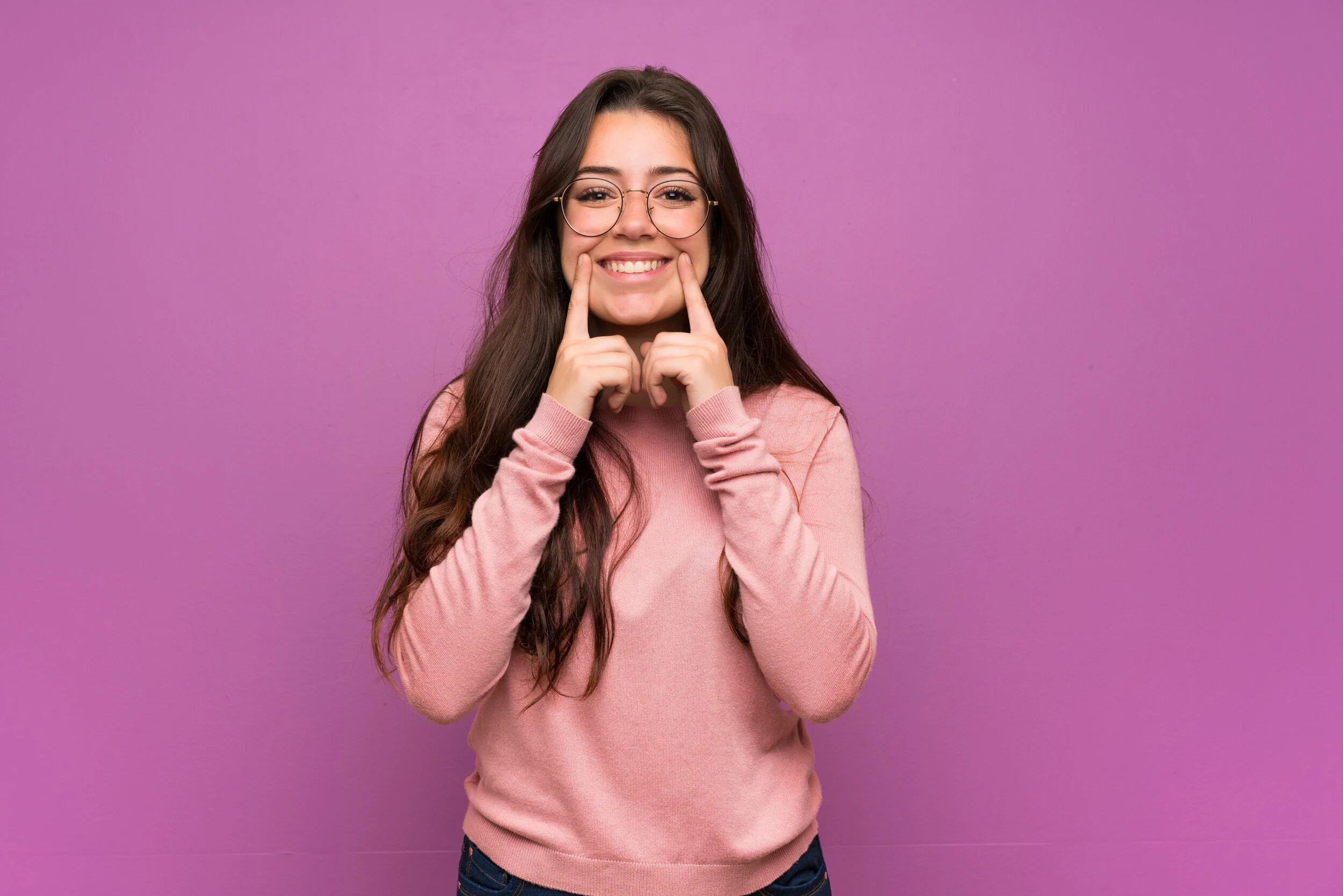 Teenager girl over purple wall smiling with a happy and pleasant expression