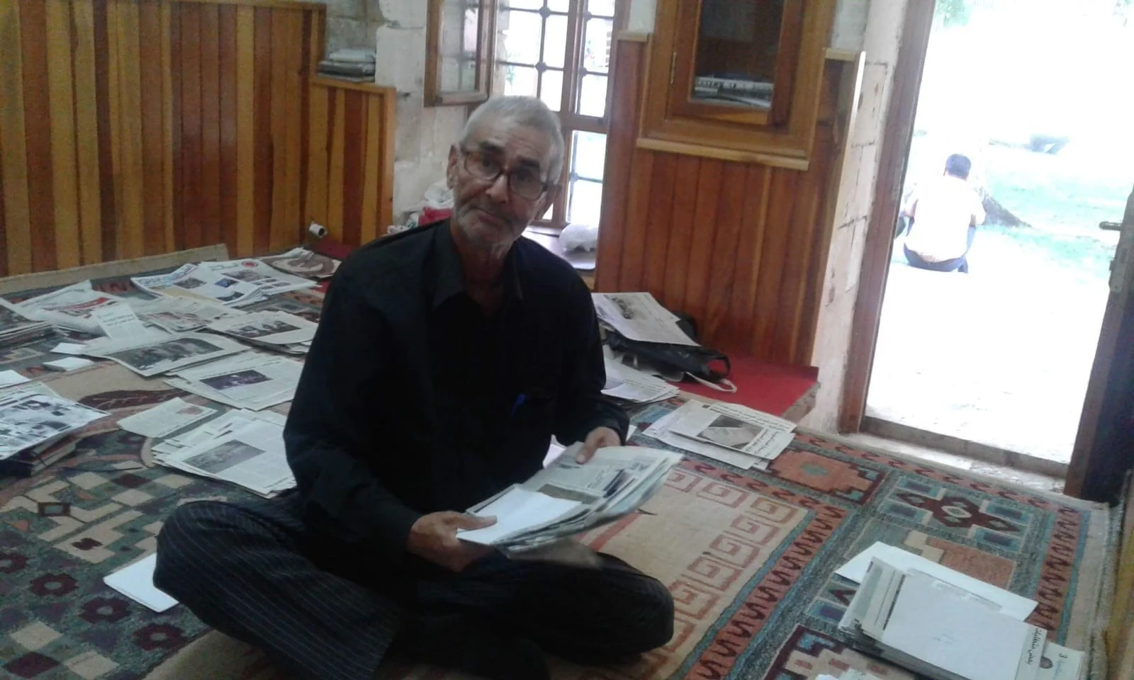 Mr. Al Taha collects newspaper articles for writing biographies in one of his house room.