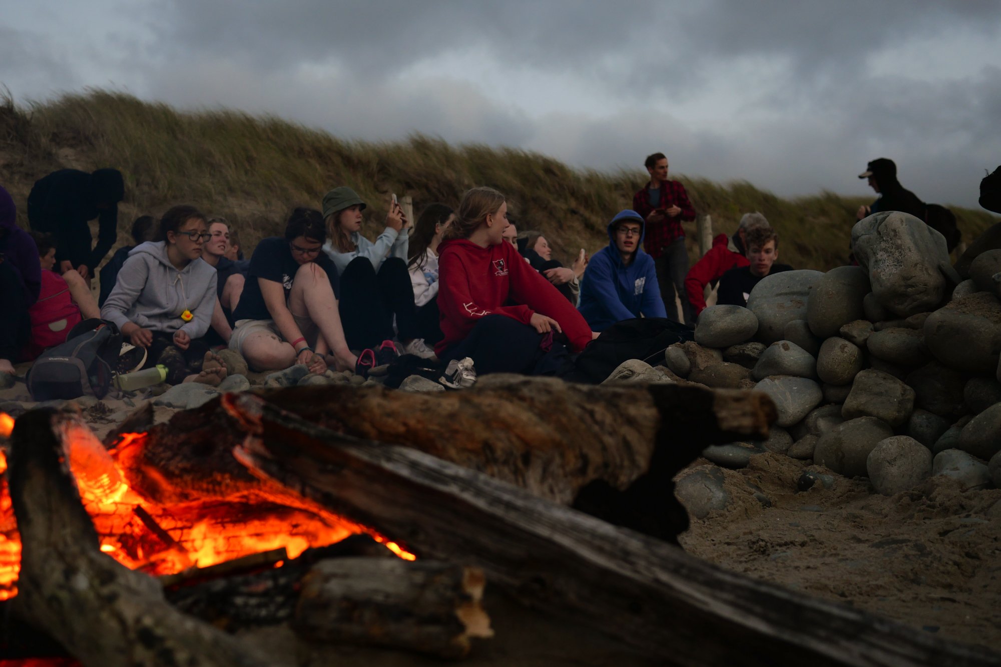 Singing songs round a campfire - summer camp on the beach