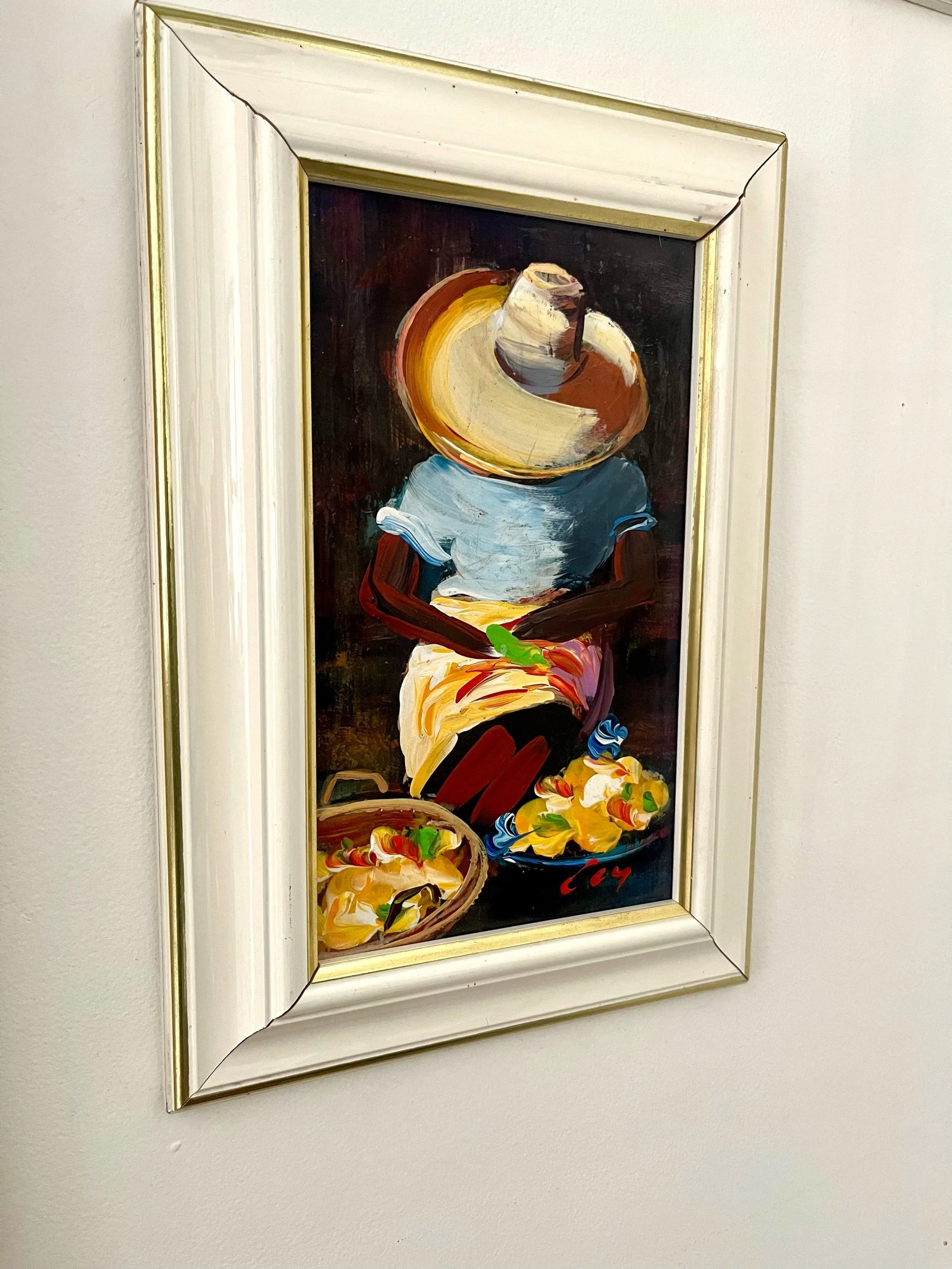 Marchande Kreyol de fruits et légumes se reposant sur une chaise avec son chapeau en paille sur la visage.