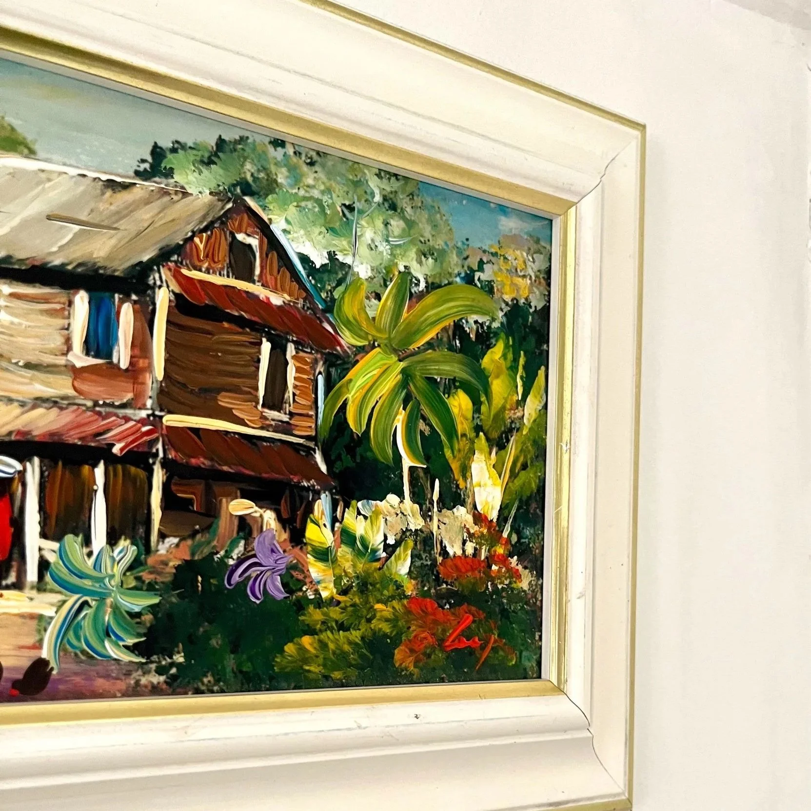 Peinture représentant un paysage de maison (kaz) créole des Caraïbes, entourée d’une végétation verdoyante et colorée.