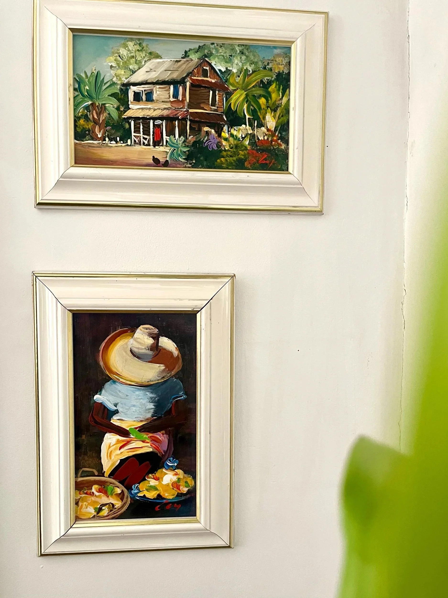 Peinture représentant un paysage de maison (kaz) créole des Caraïbes, entourée d’une végétation verdoyante et colorée.