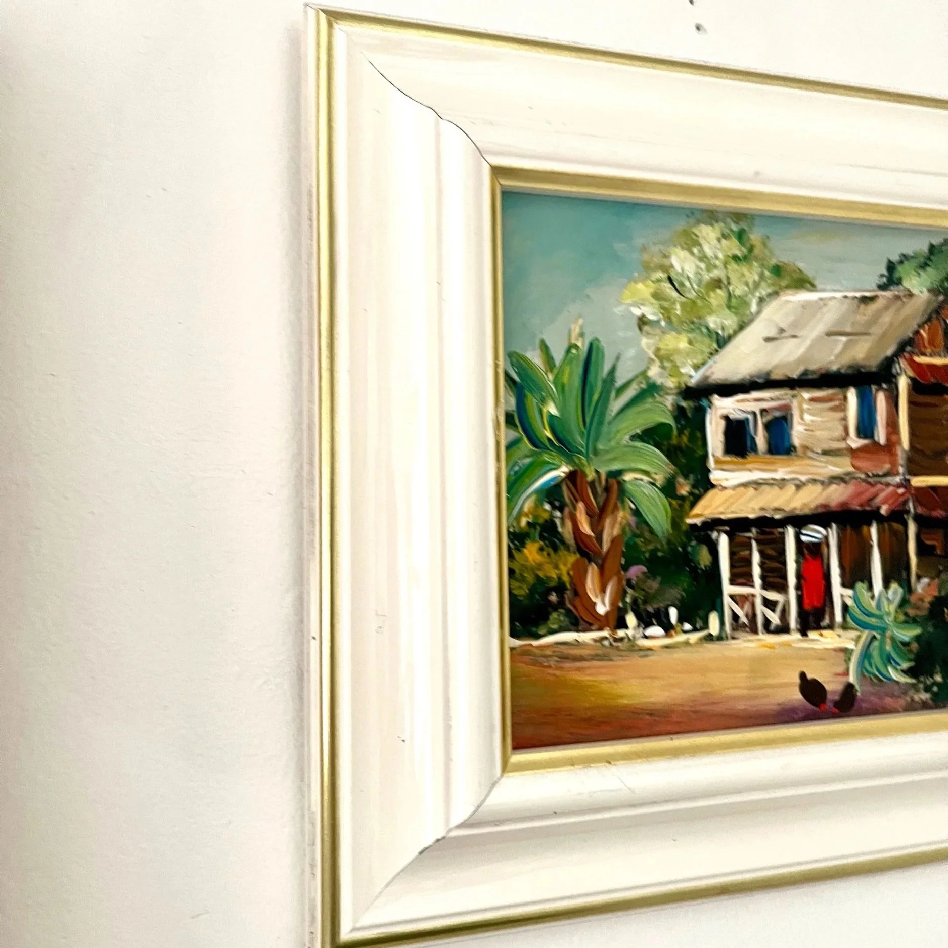 Peinture représentant un paysage de maison (kaz) créole des Caraïbes, entourée d’une végétation verdoyante et colorée.