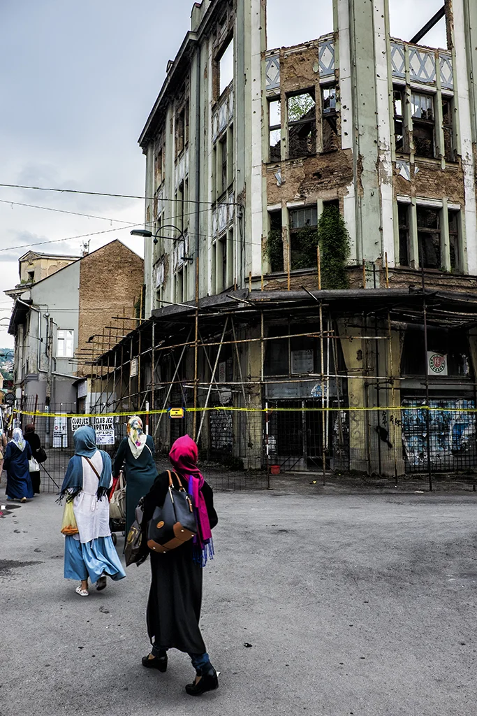 Locals look on at the war torn buildings