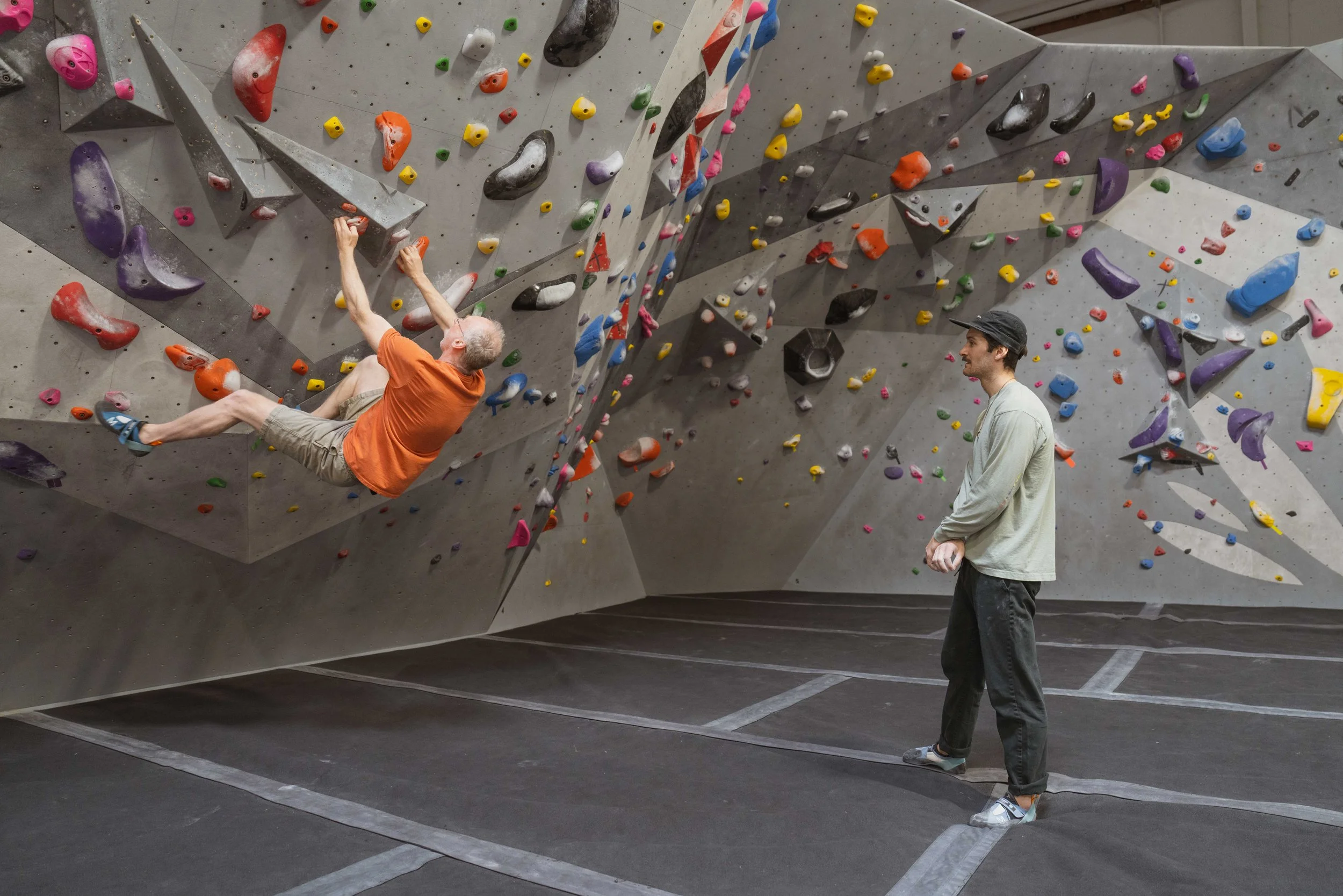 Private Instructor Devan watches a client on the wall while giving feedback on technique, sequencing, and movement analysis.