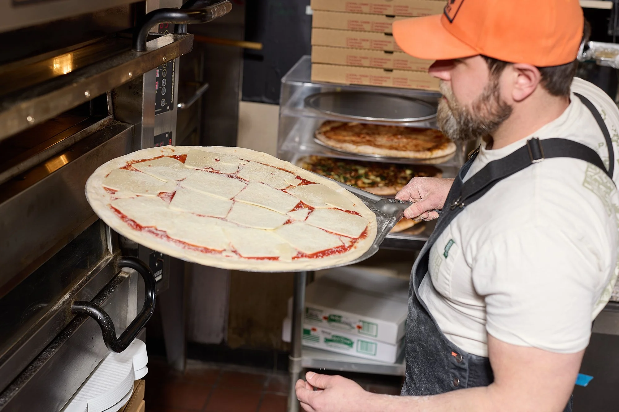 Chef putting pizza in the oven.jpg