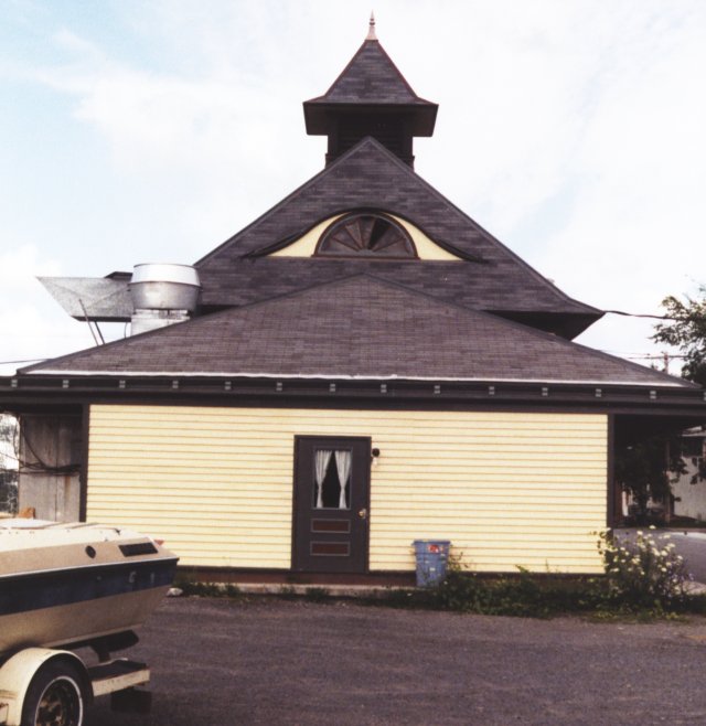 Flat on view of the east end. This gives a view of the many crazy roof angles and cupolas on the roof. Again, there is an "eyebrow" attic window on each end of the building.