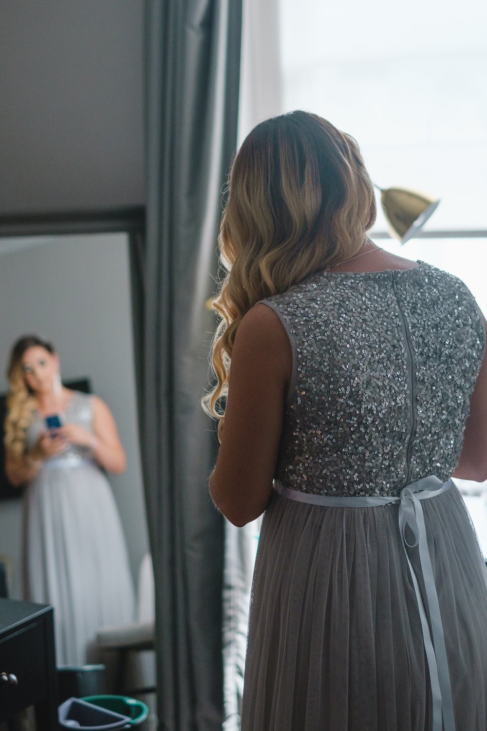 Reflection in a mirror of a bridesmaid getting ready