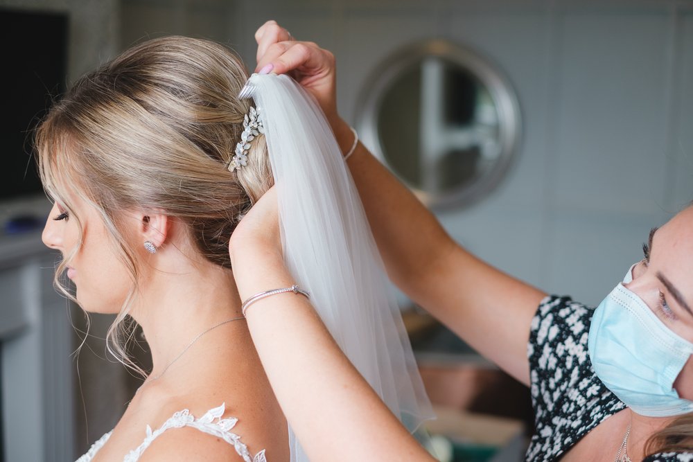 Veil being out into the bride's hair