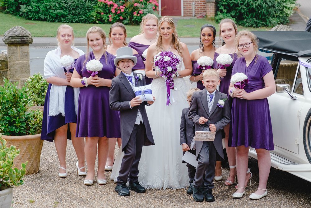 Bridesmaids in purple knee length dresses