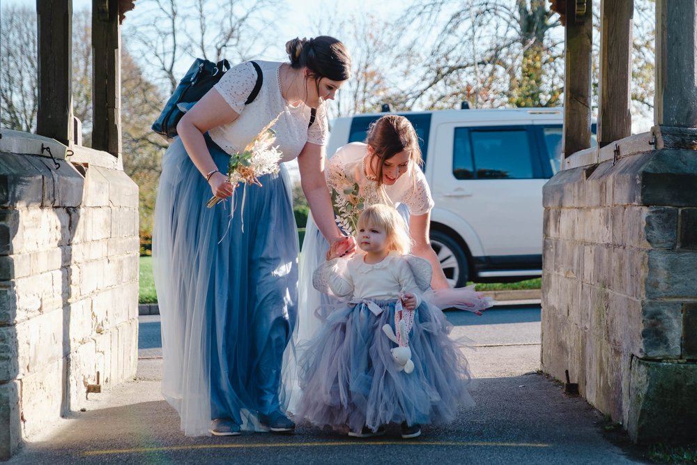 Bridesmaids and flower girl in pale blue tulle skirts with white top