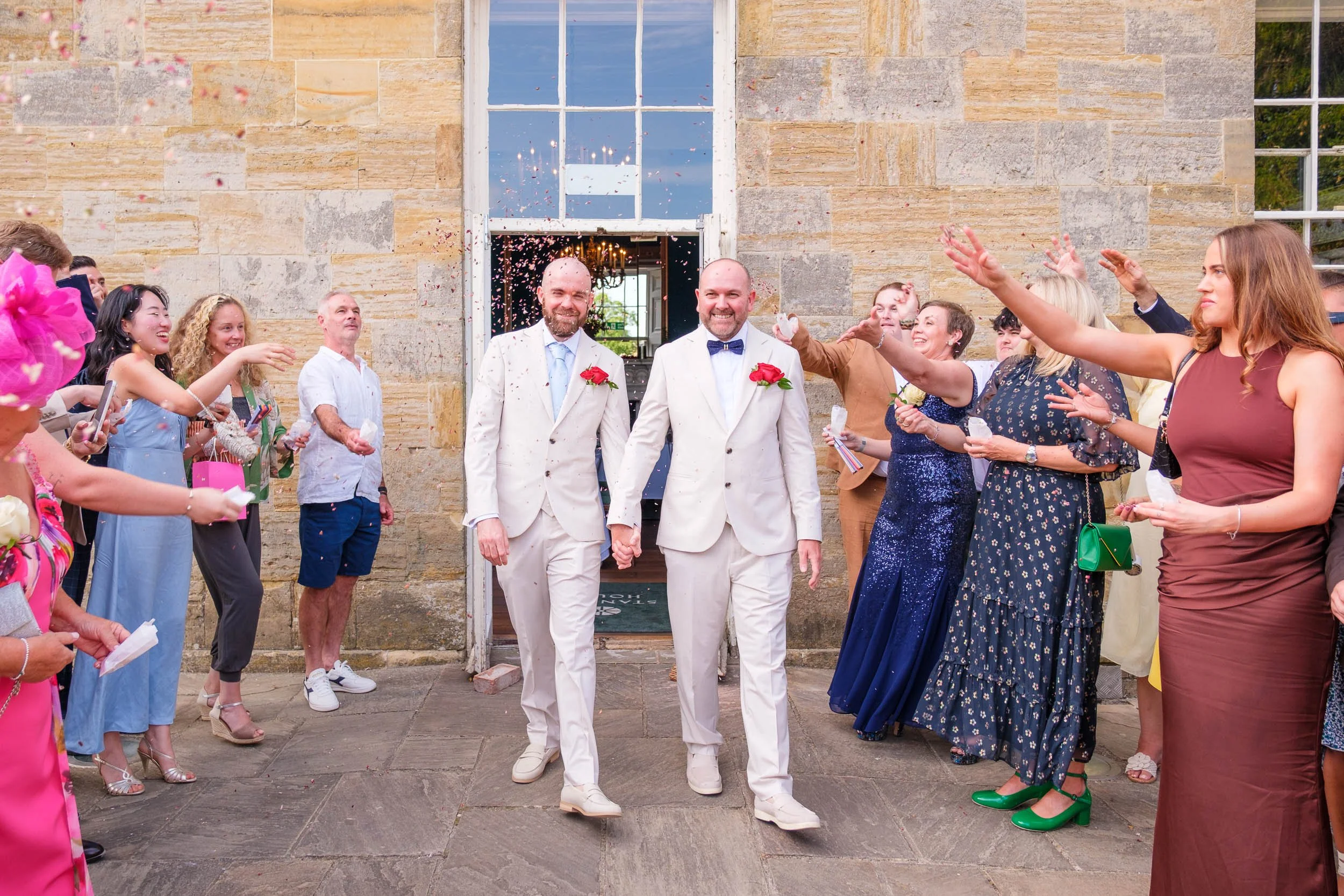 Groom and groom walking through confetti at Stanmer House Brighton