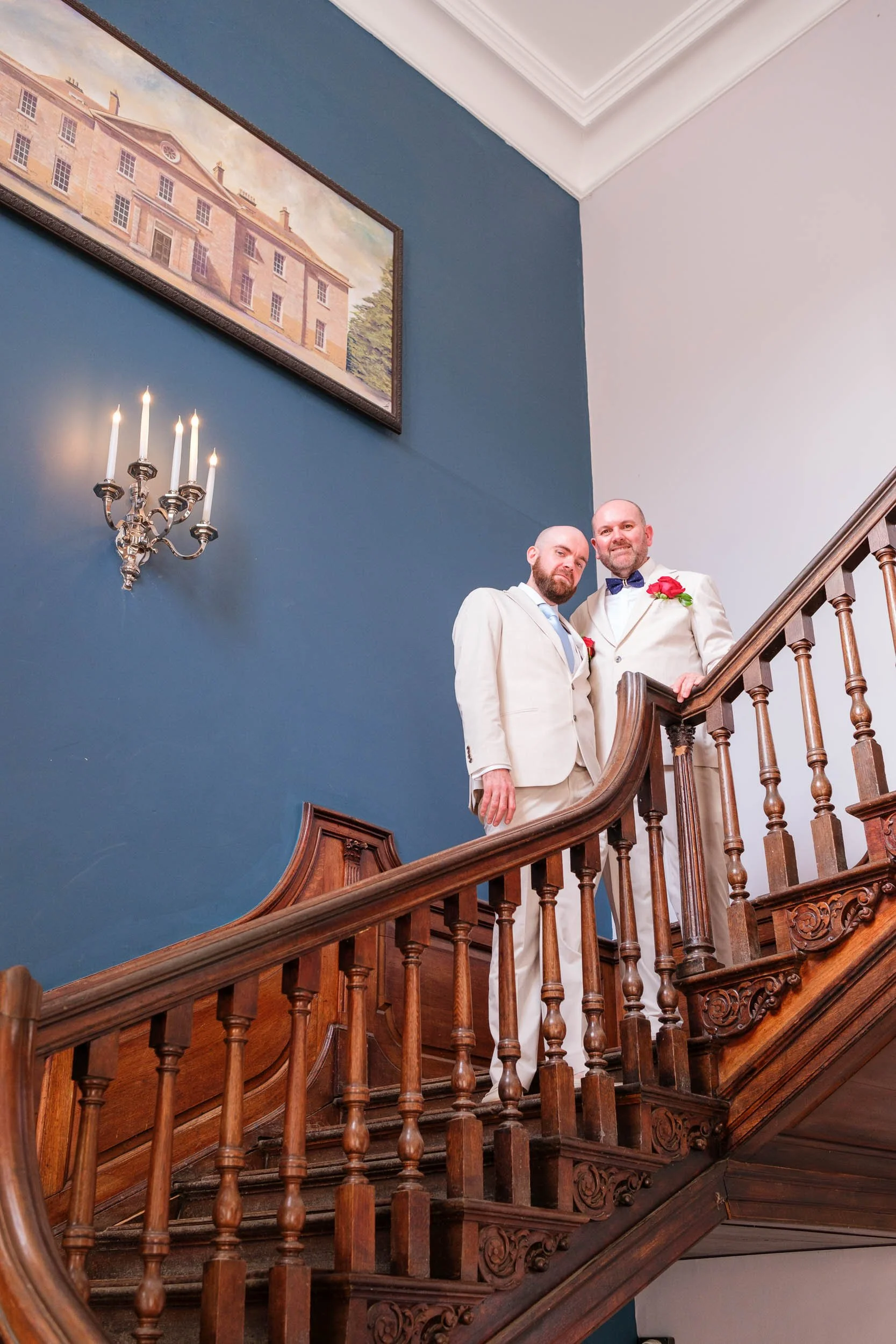 Groom and groom on the staircase at Stanmer House, Brighton