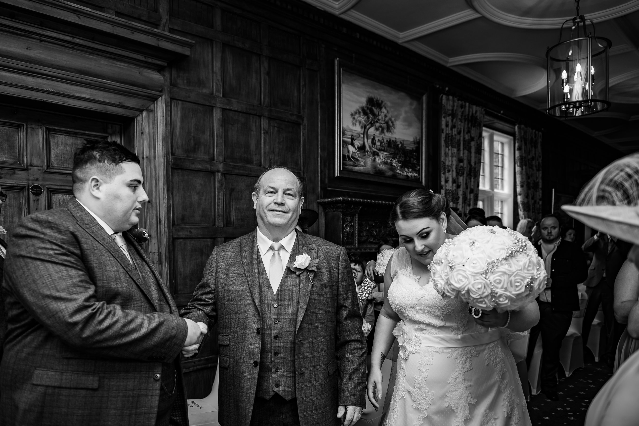 black and white wedding photography father of the bride hands her over to her future