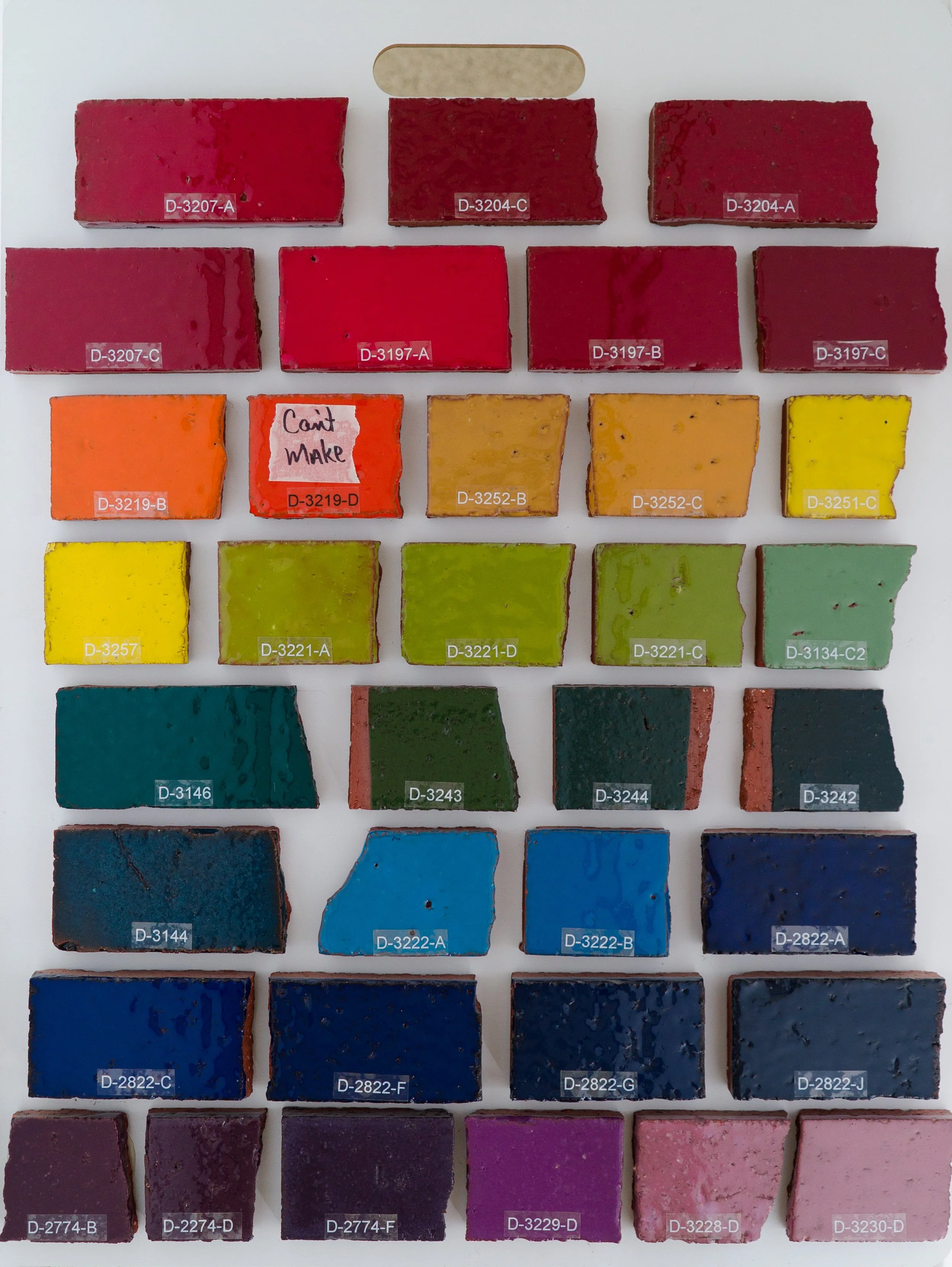 Sample display board 9 showing Gloss Glazes fired on Red Brick body at Cone 05. Codes ranges include D-3207-A to D-3230-D.