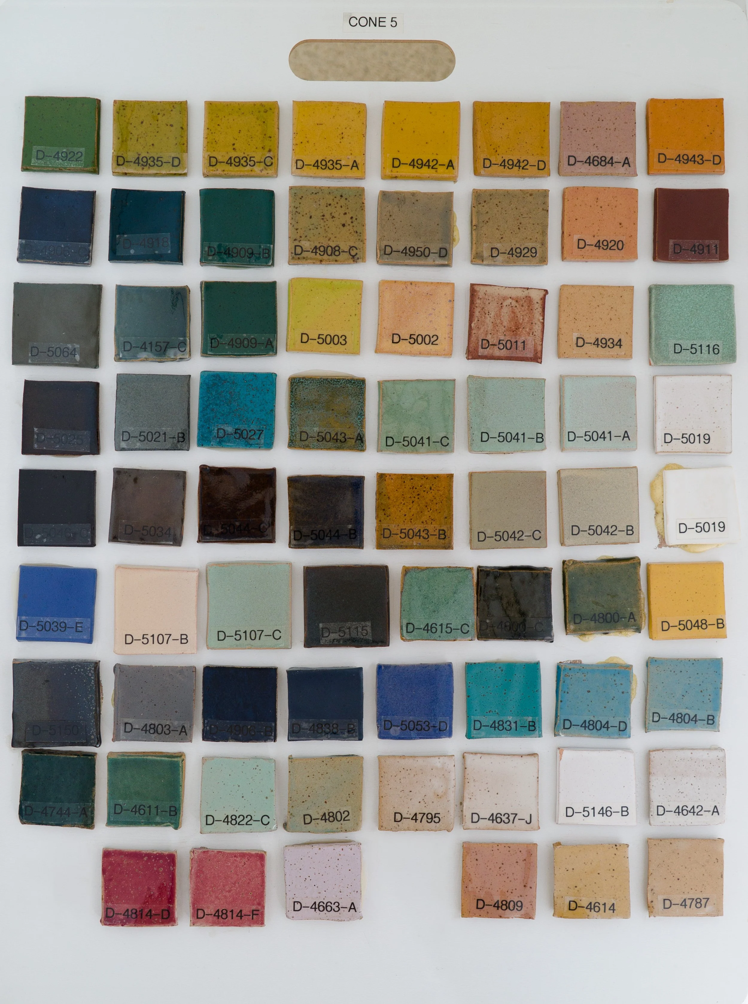 Sample tile board showing Cone 5 glazes on Speckled Buff clay body (Codes D-4922 to D-4787).