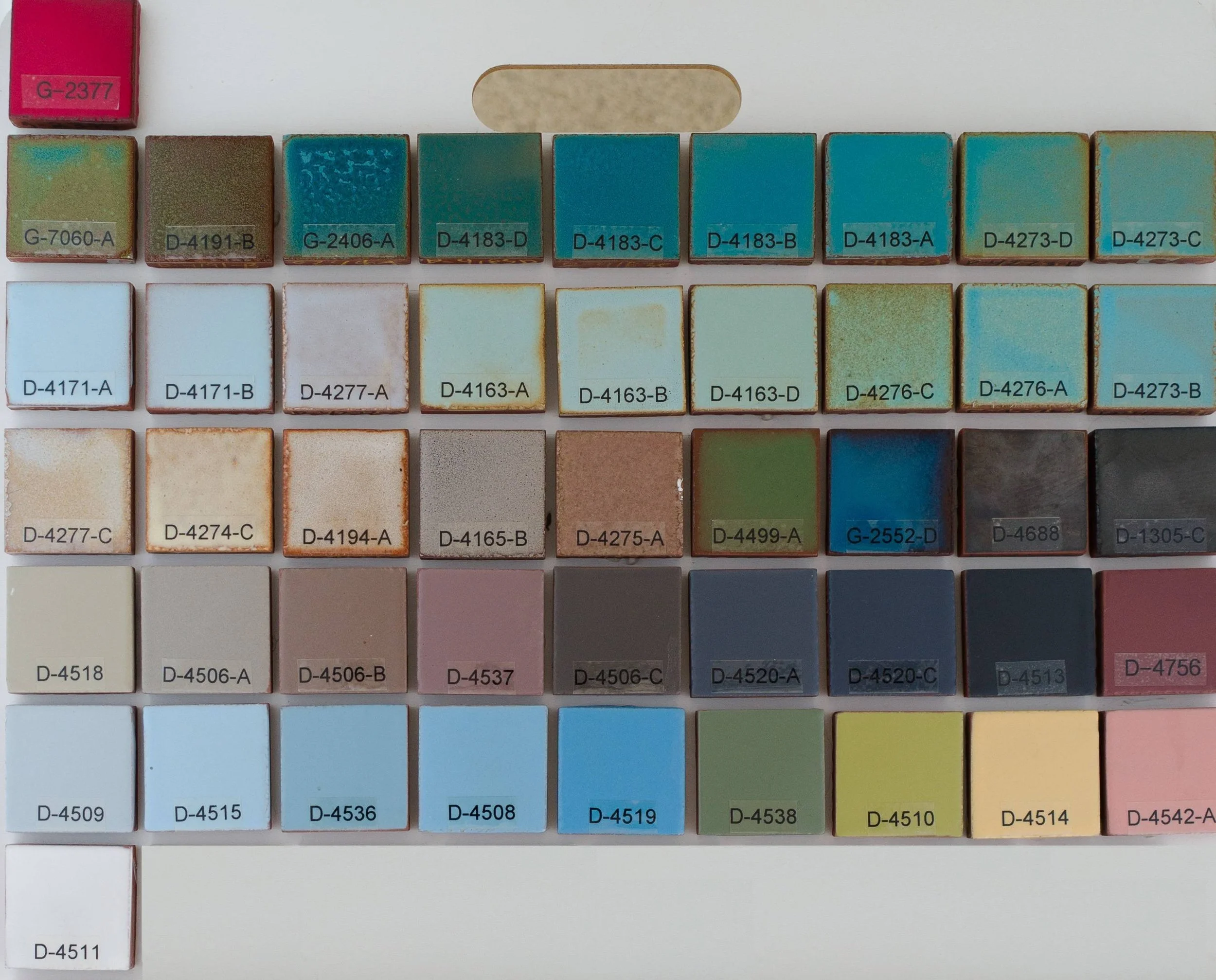 Sample display board showing Break-Up Glazes fired on Red Brick body at Cone 05. Codes ranges include G-2377 to D-4511.