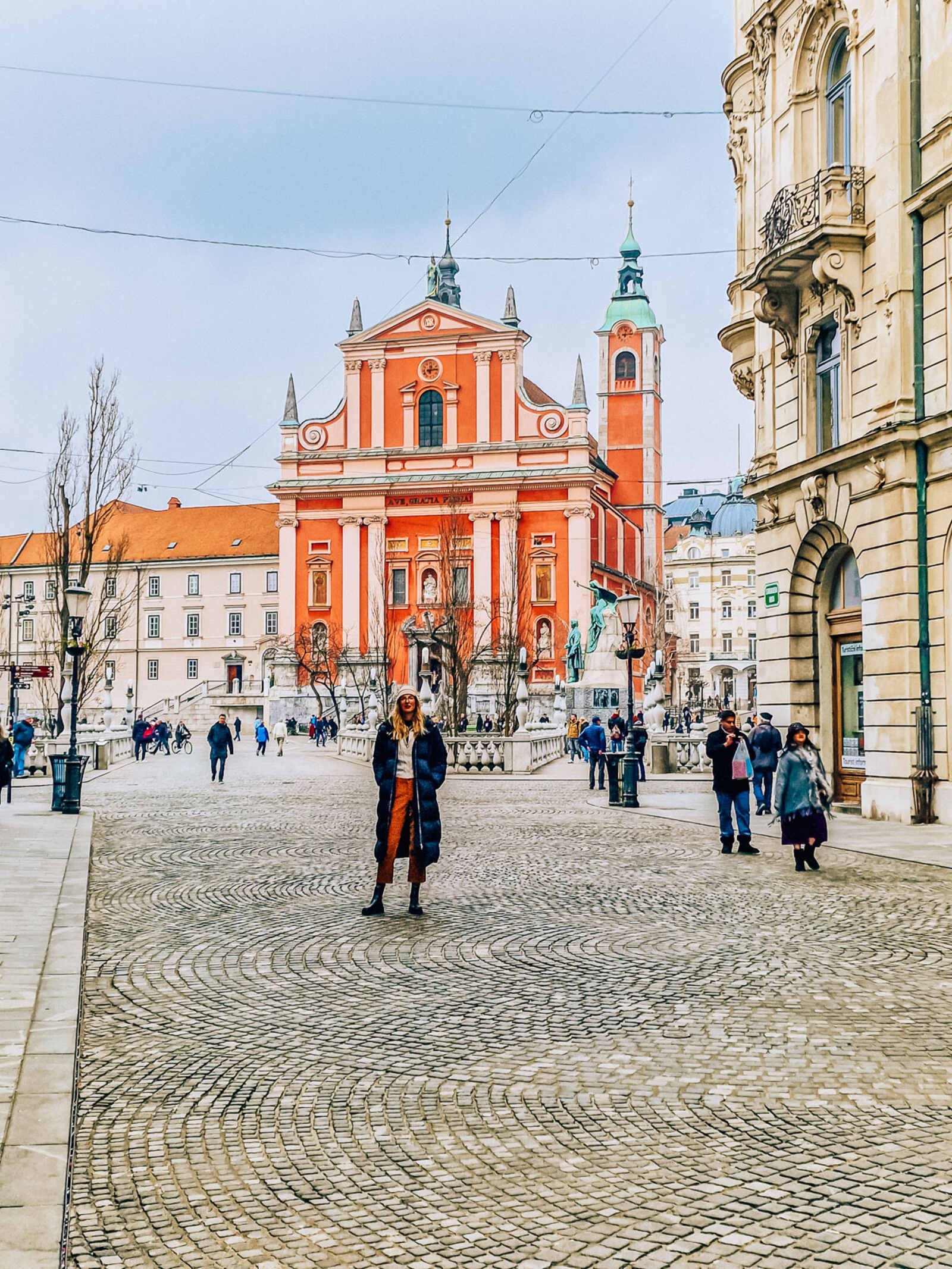 girl standing in front of a pink church in ljubljana