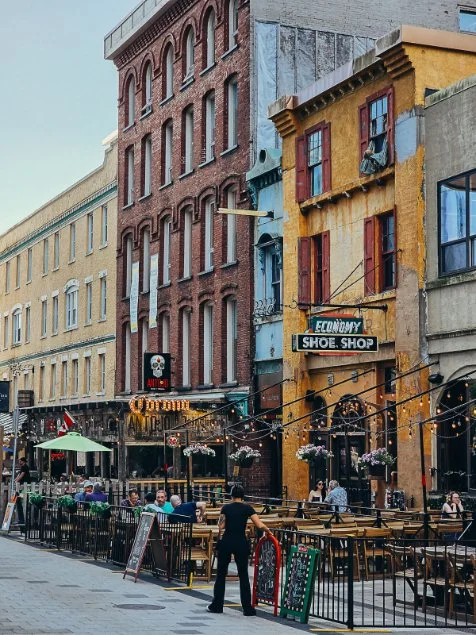Many large brick restaurants lining a walkway with outdoor seating