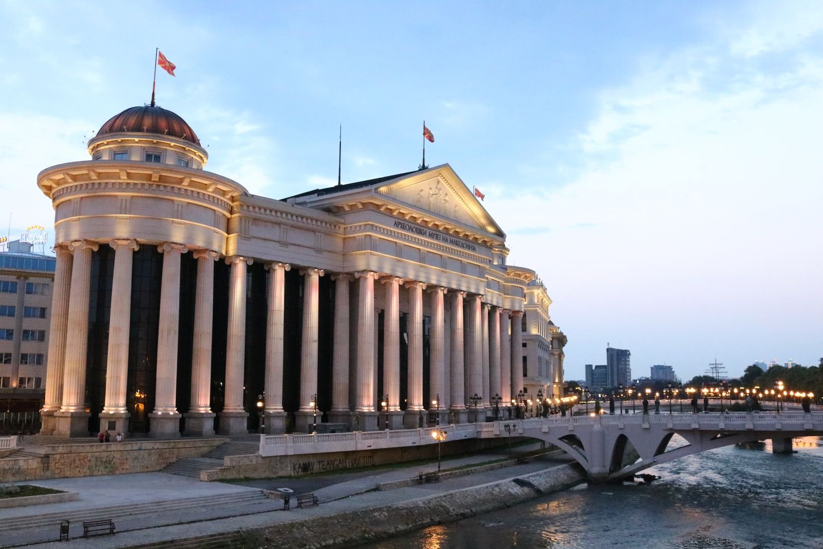 grand building with pillars lit up at dusk