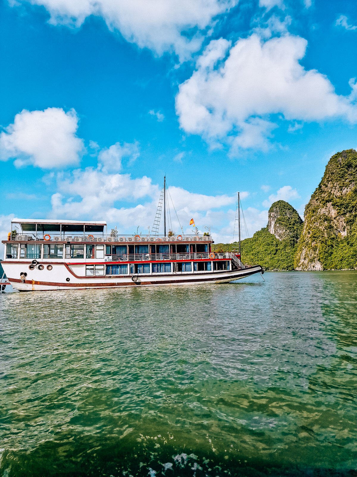 a small, 3 deck cruise ship in Ha long bay vietnam