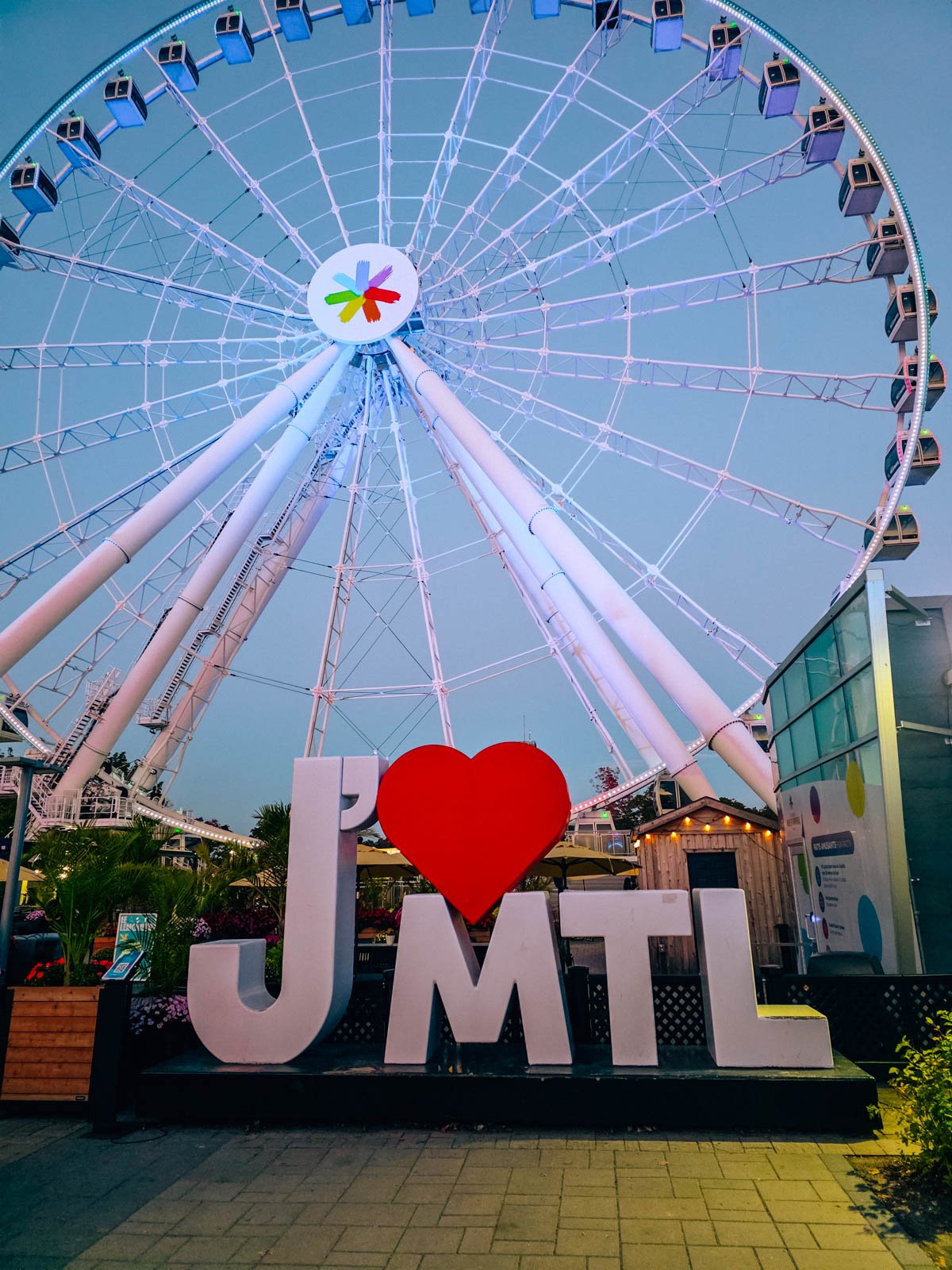 A large ferris wheel in the background with a sign in front that says "J'aime MTL" but the "aime" is a heart