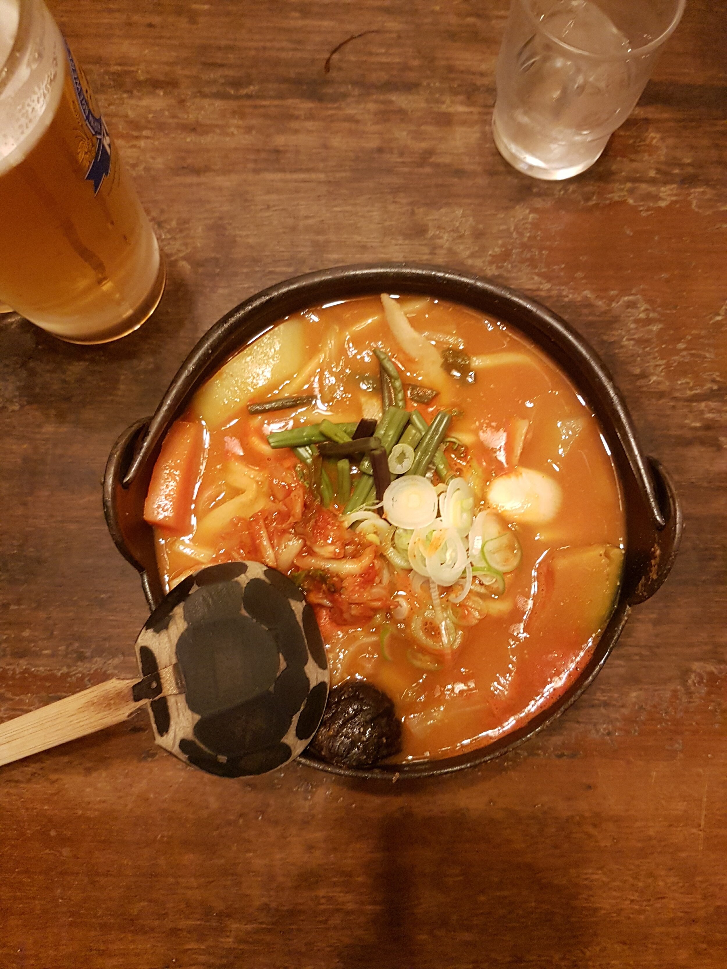 A big bowl of Hoto noodles with a large wooden spoon on a table