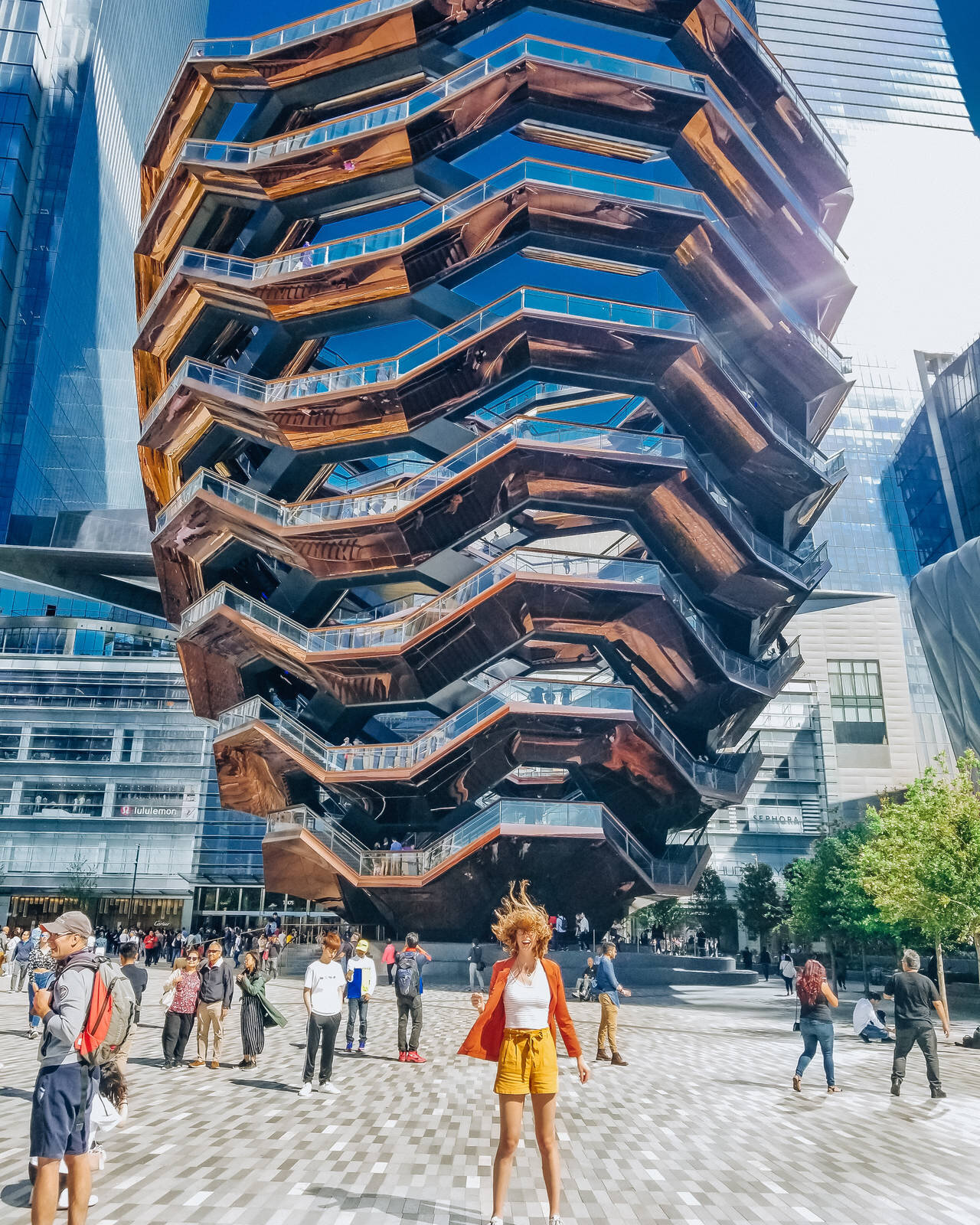 Hudson Yards The Vessel attraction with a girl in the wind