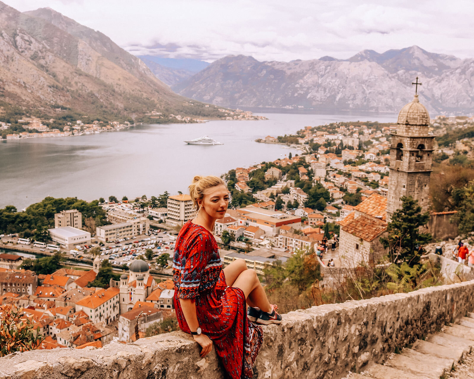 girl sitting on a wall looking over Kotor in Montenegro