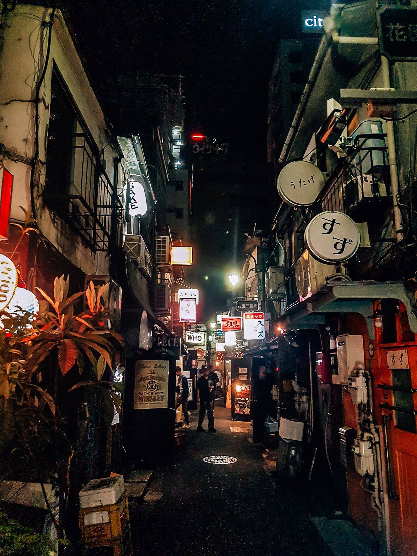 The dark small alley of Golden Gai covering signs and small bars